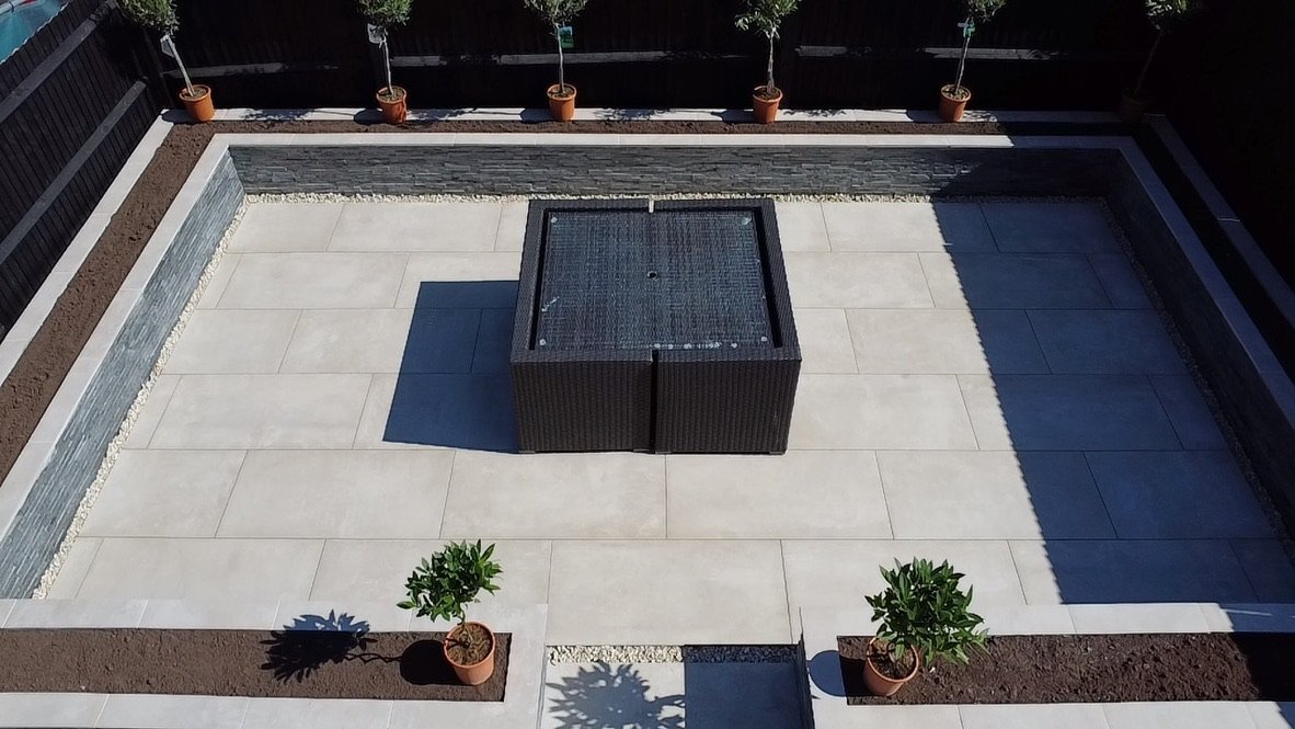 Nowoczesny i stylowy taras w kolorze kremowym, z dużych płyt, które podkreślają poczucie przestrzeni i elegancji.
