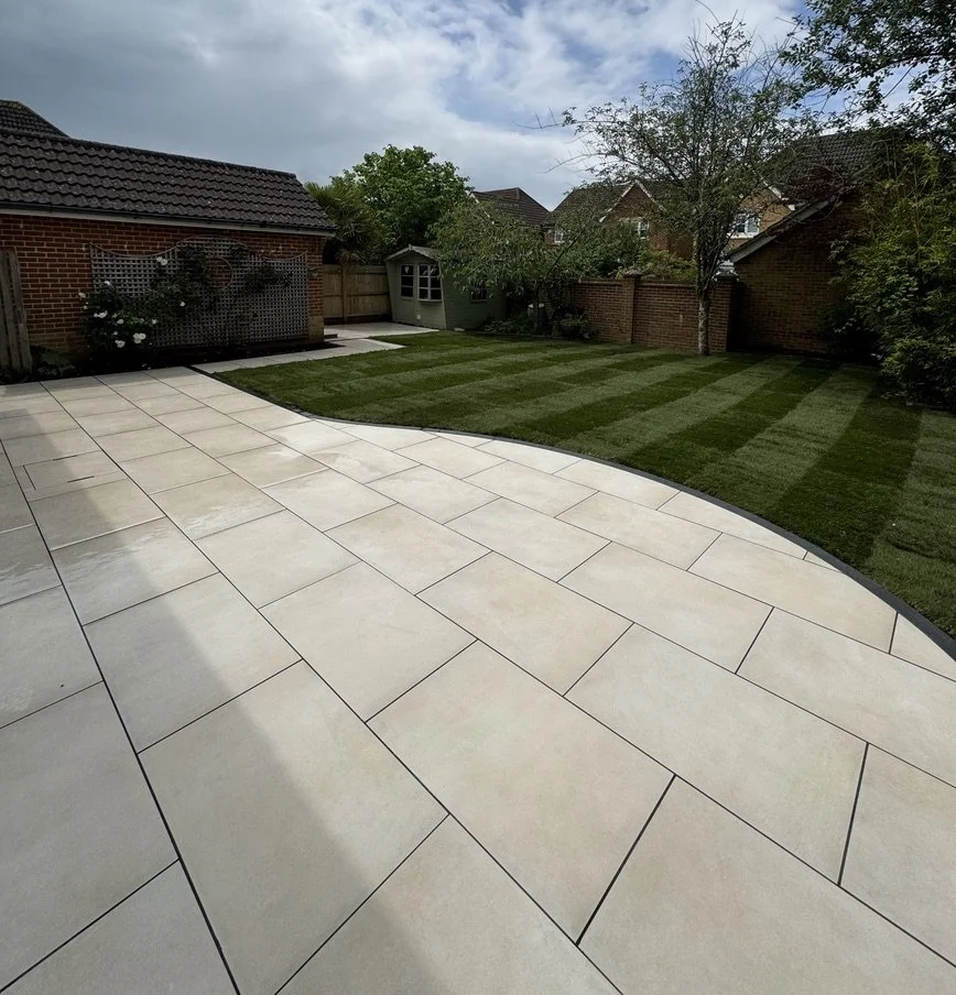 Elegancki taras z dużych płyt porcelanowych w kolorze kremowym – jasne i nowoczesne rozwiązanie na zewnątrz z gładkim, jednolitym wykończeniem.
