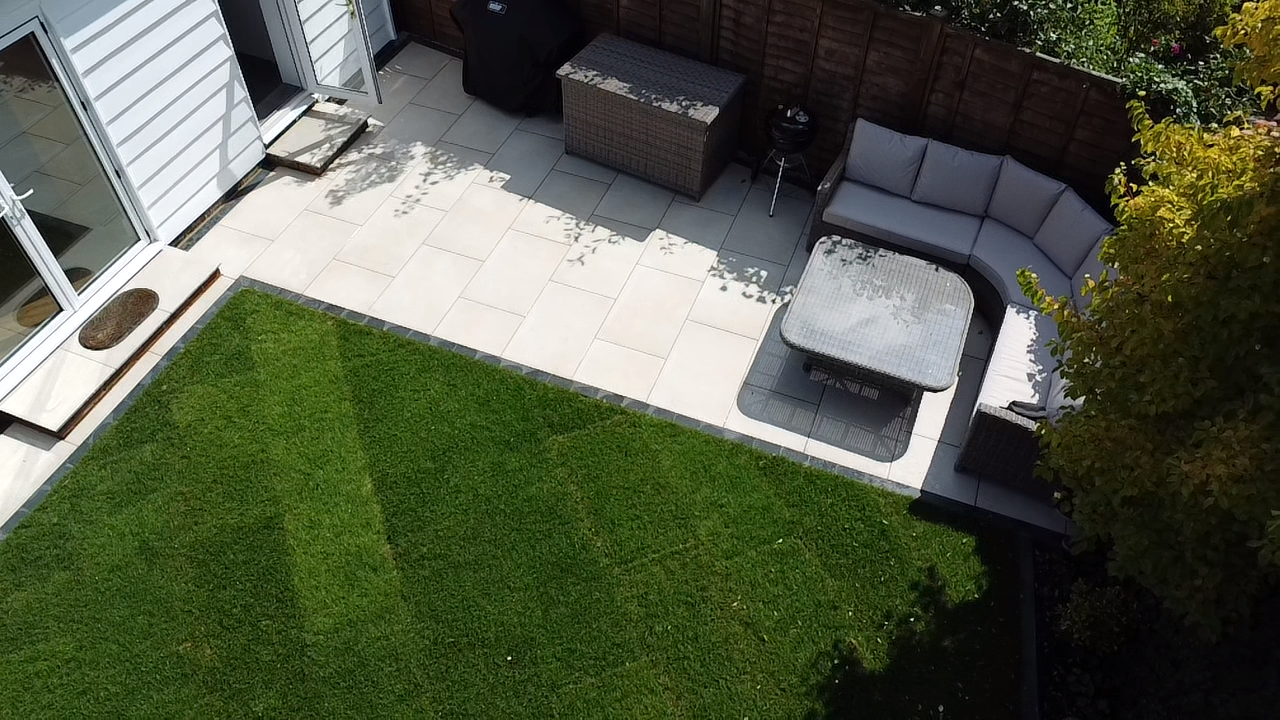 Przemiana ogrodu w przestrzeń do relaksu o niskich wymaganiach pielęgnacyjnych, z wykorzystaniem płyt porcelanowych Venetian Beige oraz kostki porcelanowej Charcoal, zapewniająca stylowe i trwałe wykończenie.
