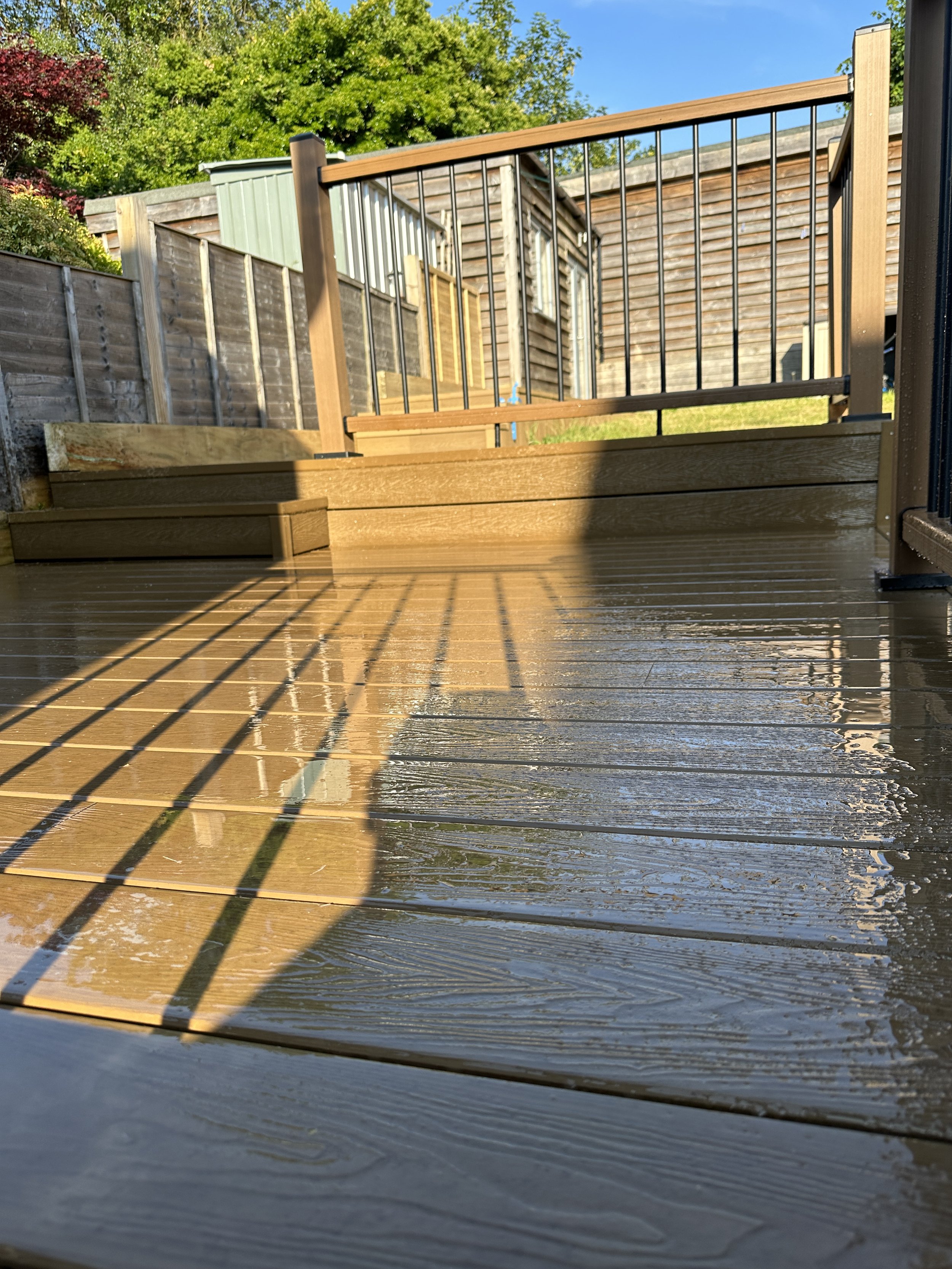 Trwały i antypoślizgowy taras kompozytowy w ciepłych odcieniach Teak, wykonany z materiałów **NeoTimber Essential**.
