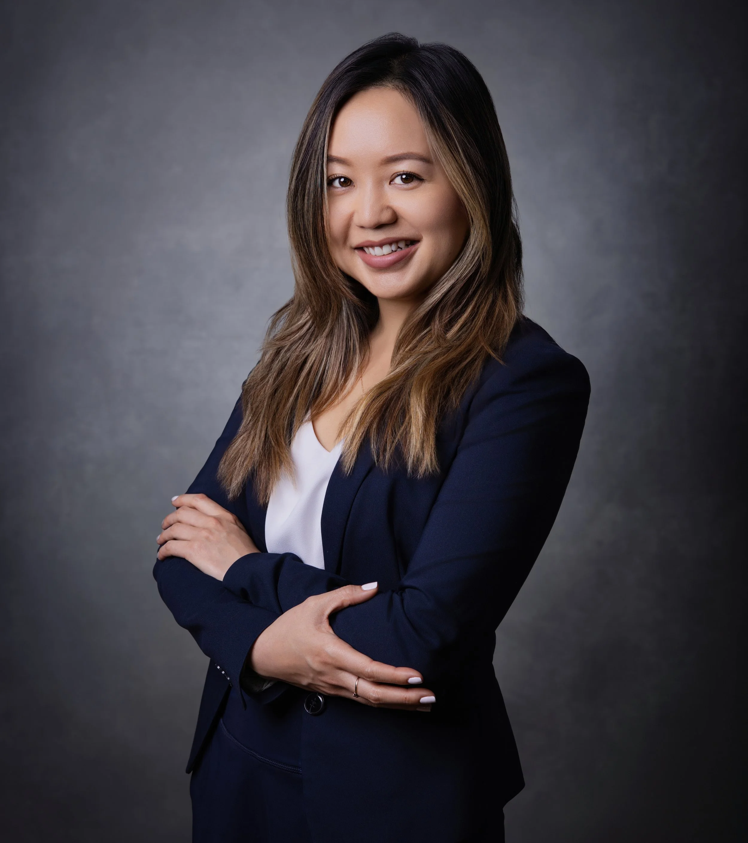 Business Headshot of Joanna Leung wearing a navy business suit.