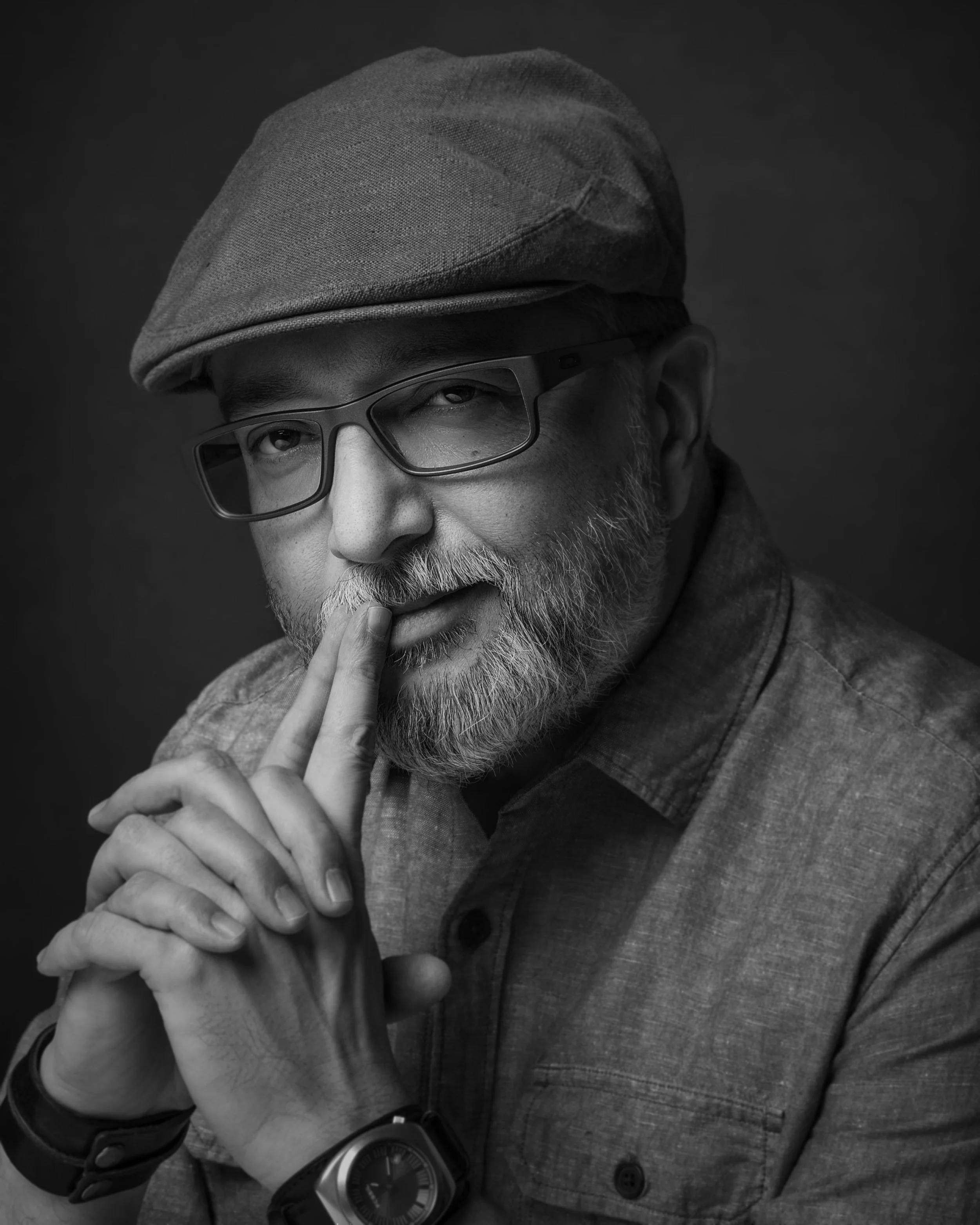 Black and white portrait of Toronto photographer and sci-fi author Warren Shepherd wearing a flat cap and looking pensive