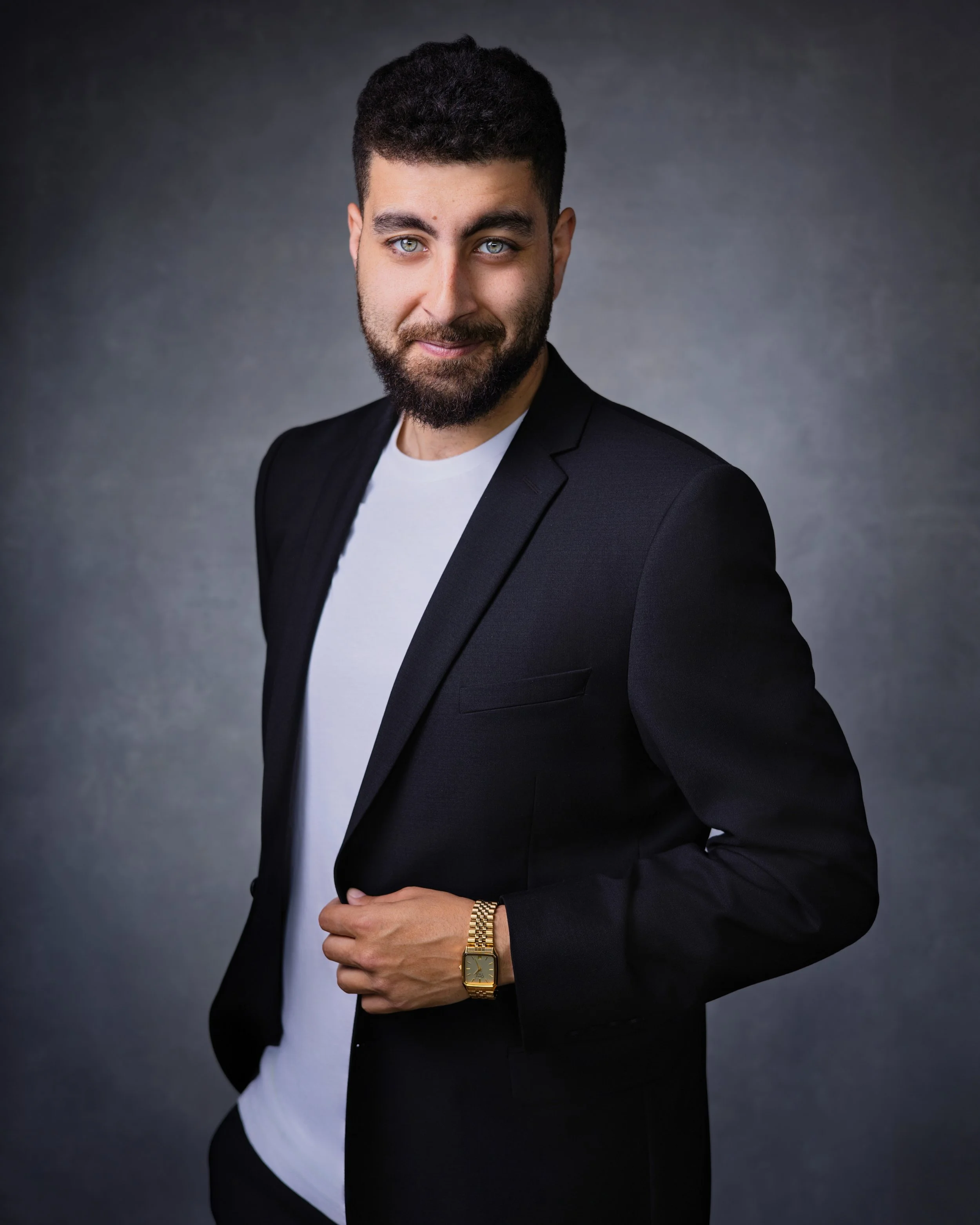 Business Headshot of Peter Aziz wearing navy blazer and white dress t-shirt.