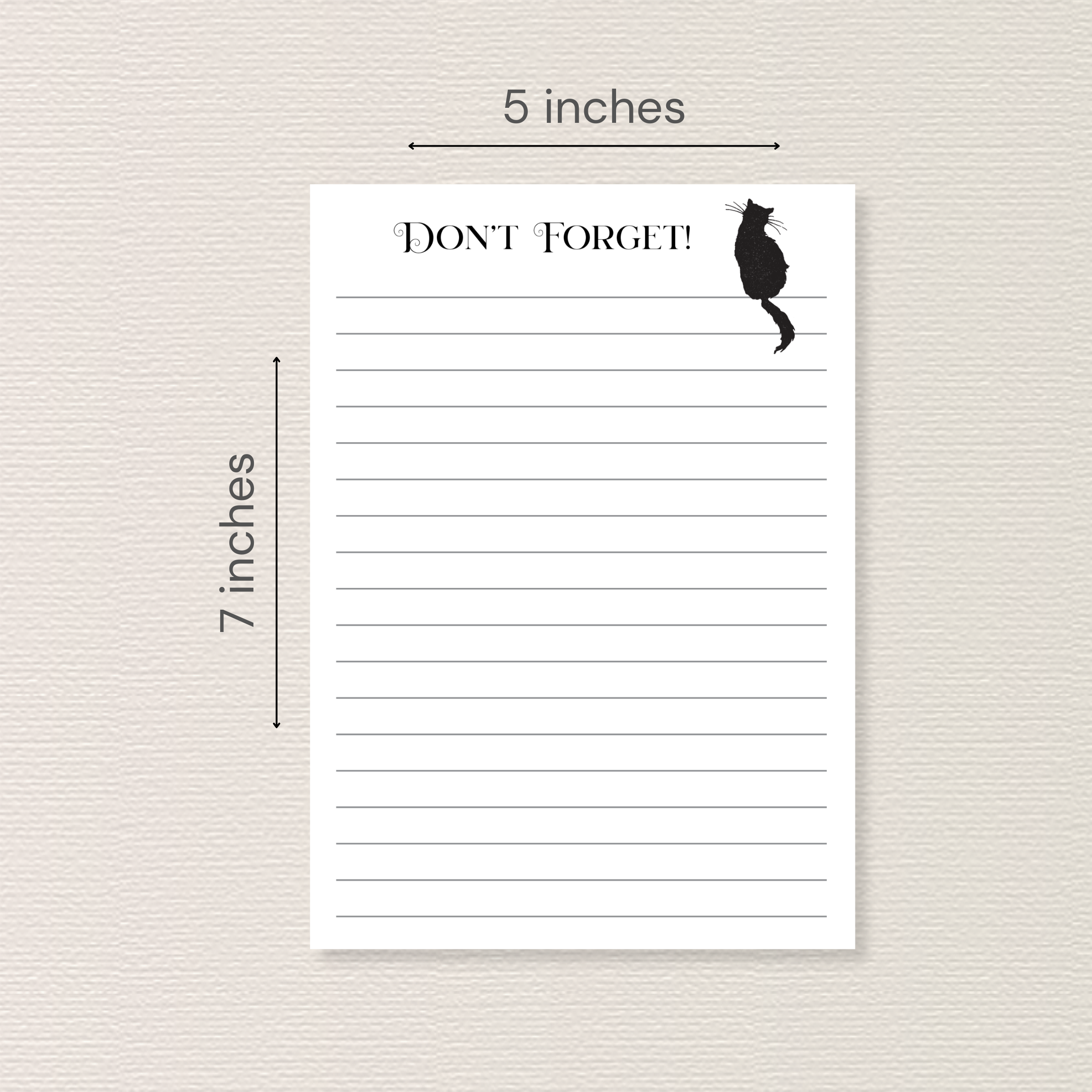 Notepad with black cat sitting on top line. Arrows and text next to image indicate the pad measures 5x7 inches.