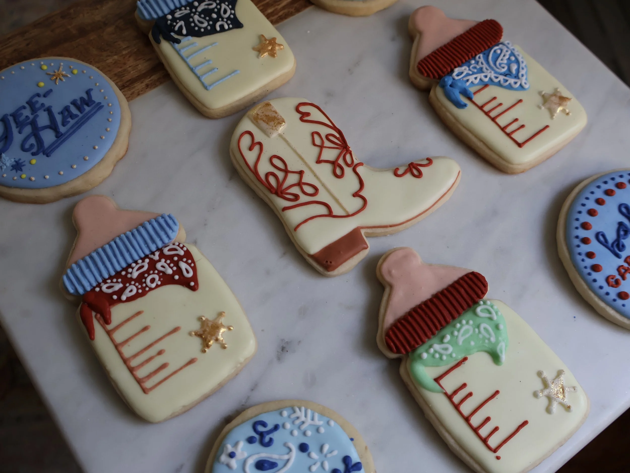 Decorated Christmas cookies featuring holiday themes, including snowflakes, Christmas stockings, and Santa hats, with colorful icing and gold accents.