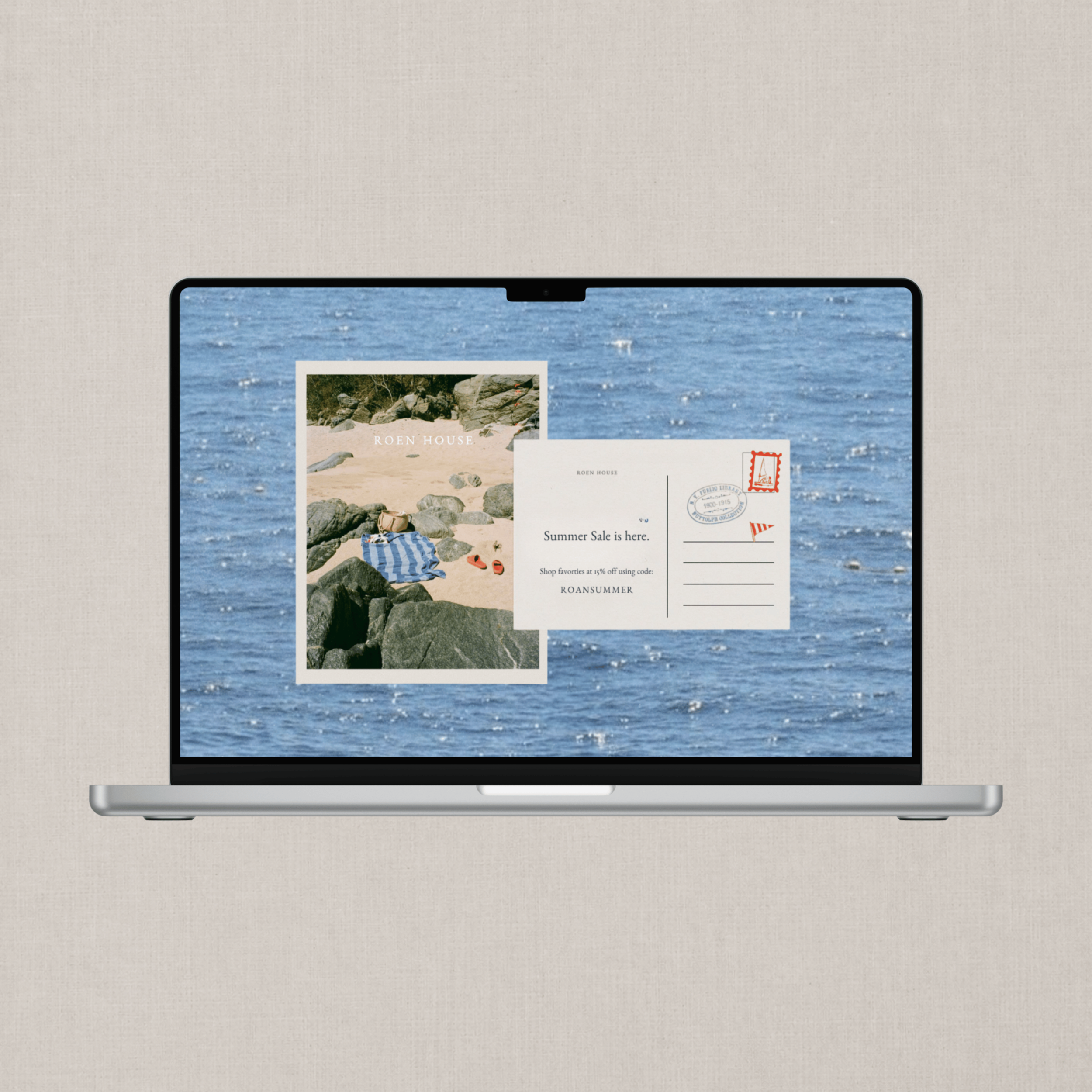 View of a sleek, modern computer monitor displaying a webpage with a beach scene, rocks, and sand, alongside promotional text about a summer sale.