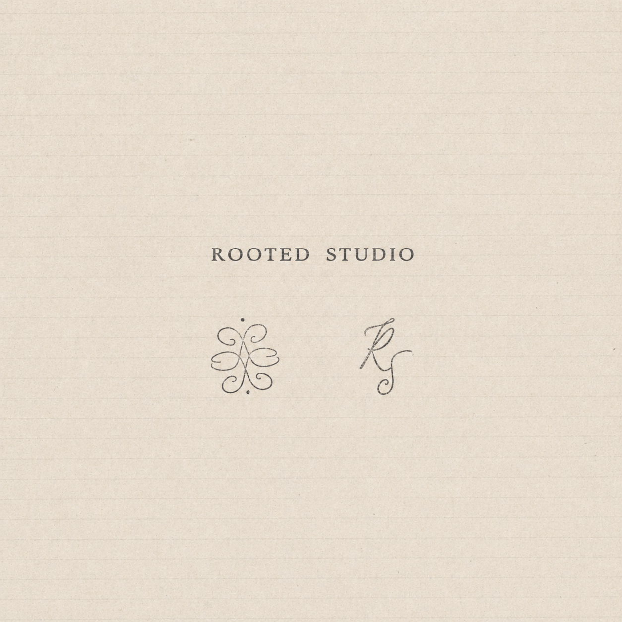 A cream-colored textured paper with the words 'Rooted Studio' printed in black, along with decorative symbols and initials 'A' and 'K'.