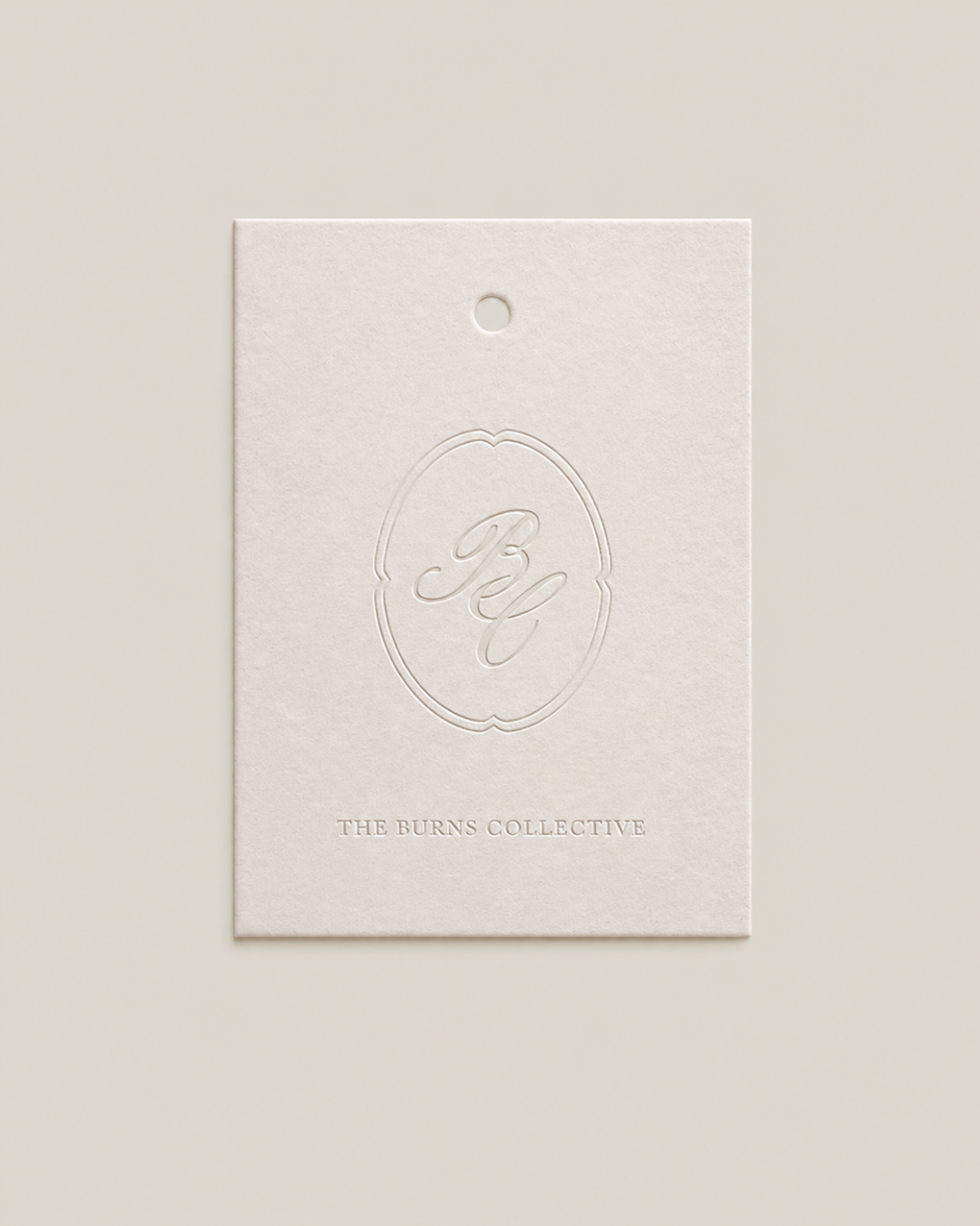 Embossed card with a decorative logo and the text 'THE BURNS COLLECTIVE' on a light background.