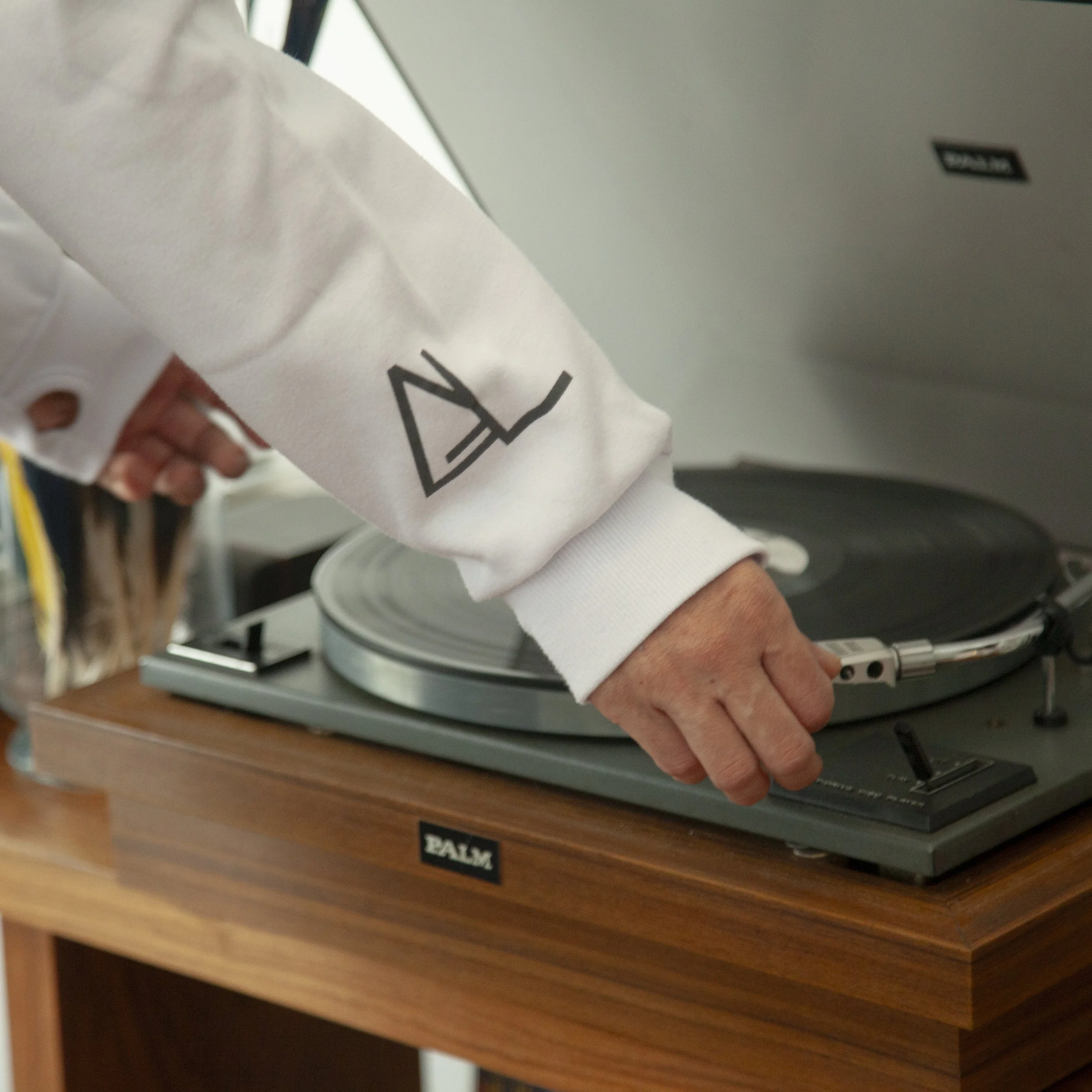 A person adjusting a turntable on a wooden table.