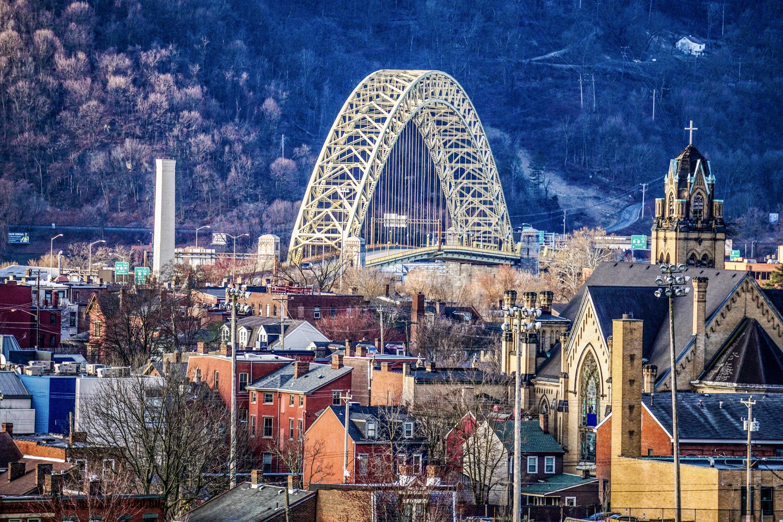 Pittsburgh West End bridge arch spanning a hillside neighborhood below.