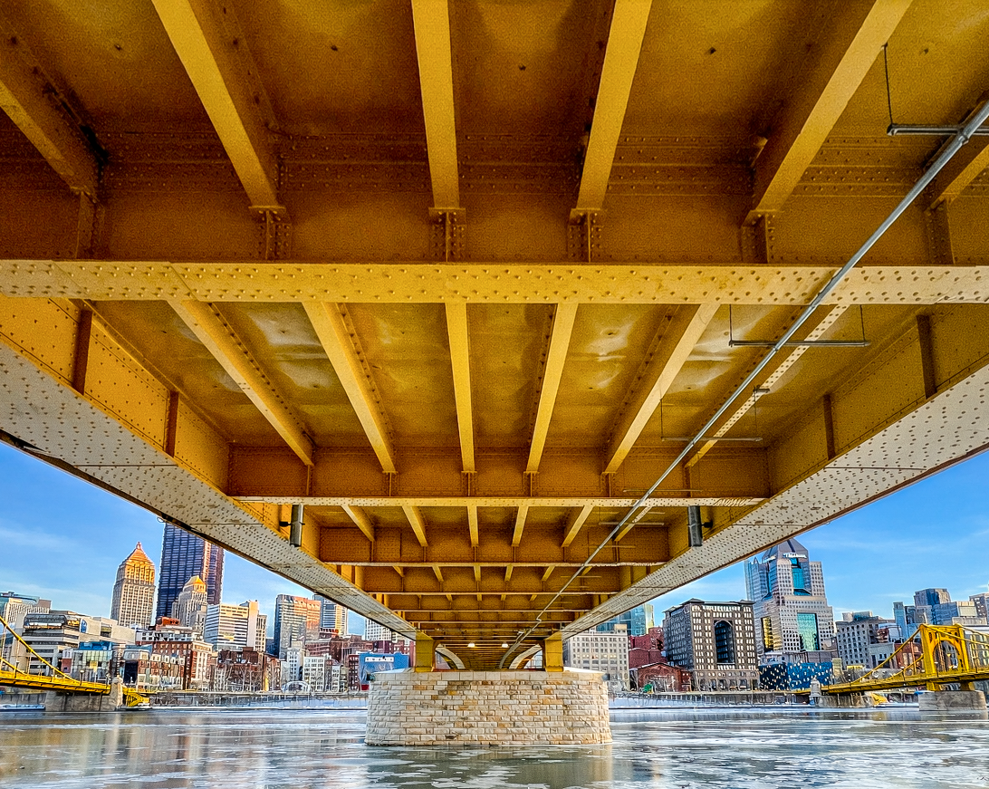 Steel beams and underside of a Pittsburgh bridge viewed from below.