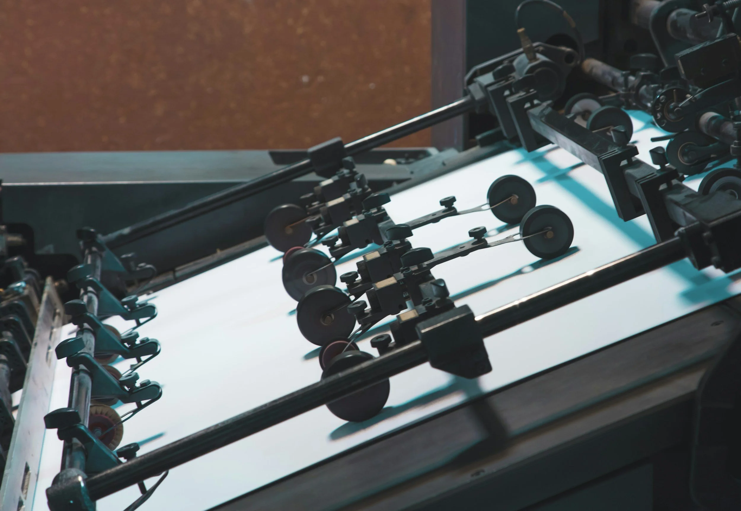 Close-up of a printing press with rollers and paper feed mechanism.
