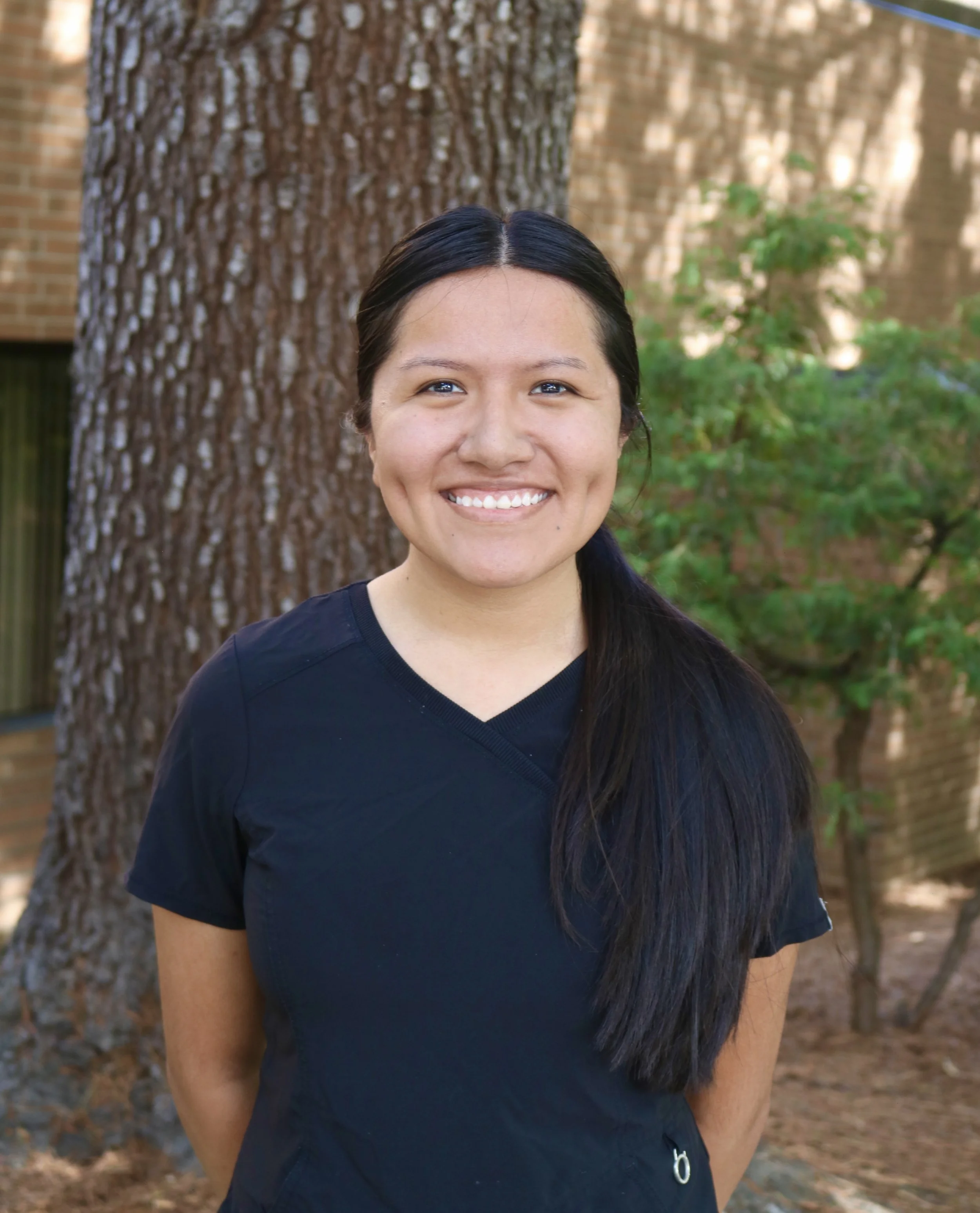 Laura, a dental hygienist, smiling outside of the dental clinic.