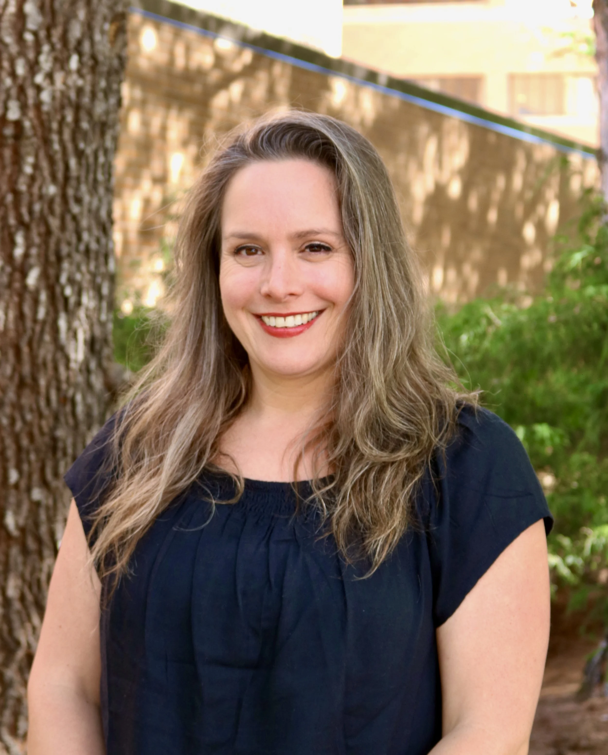 Jessica, patient care coordinator, smiling outside the dental clinic.