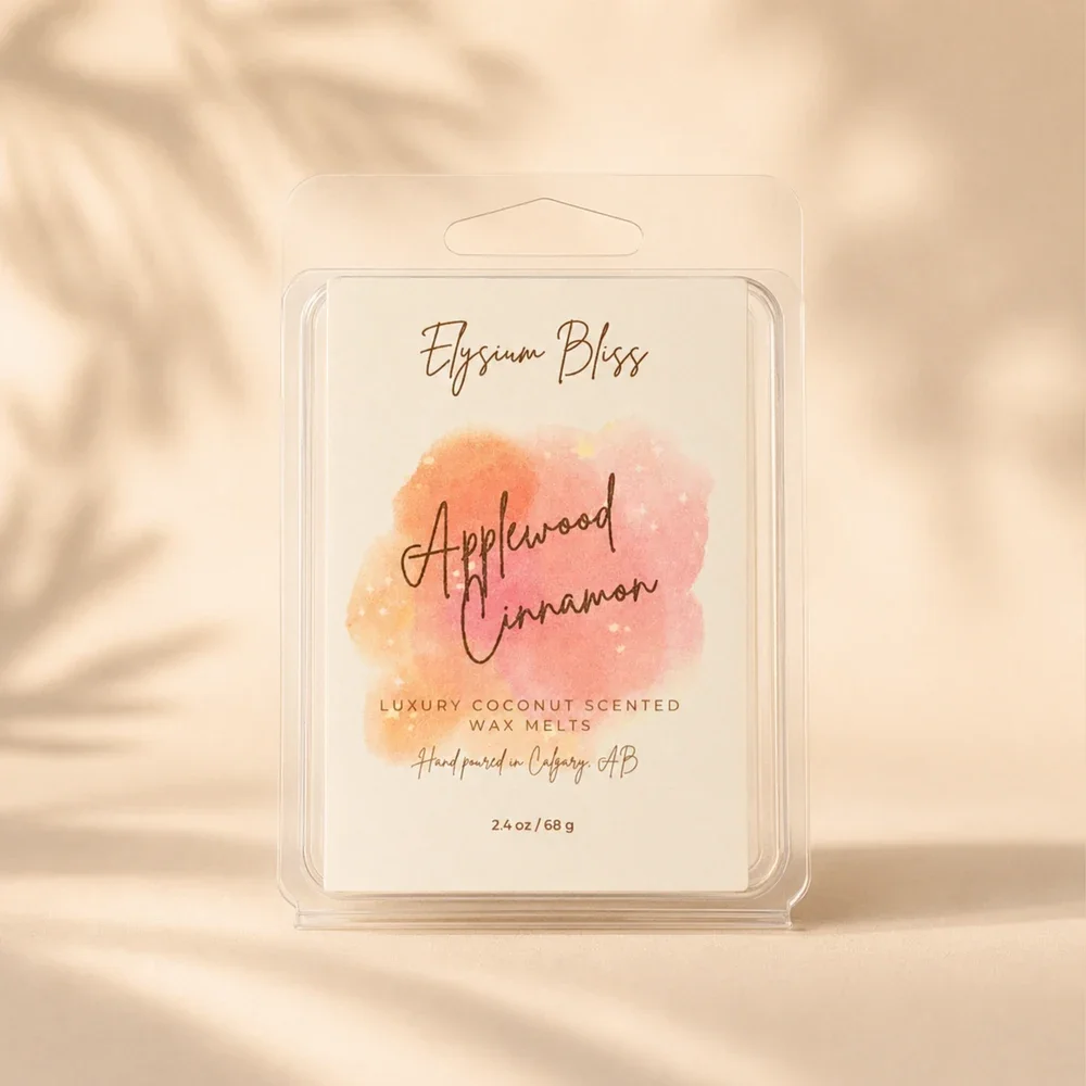 Elysium Bliss Applewood Cinnamon luxury coconut wax melts in a clear clamshell with watercolour label, on a warm cream background with soft palm-frond shadow.
