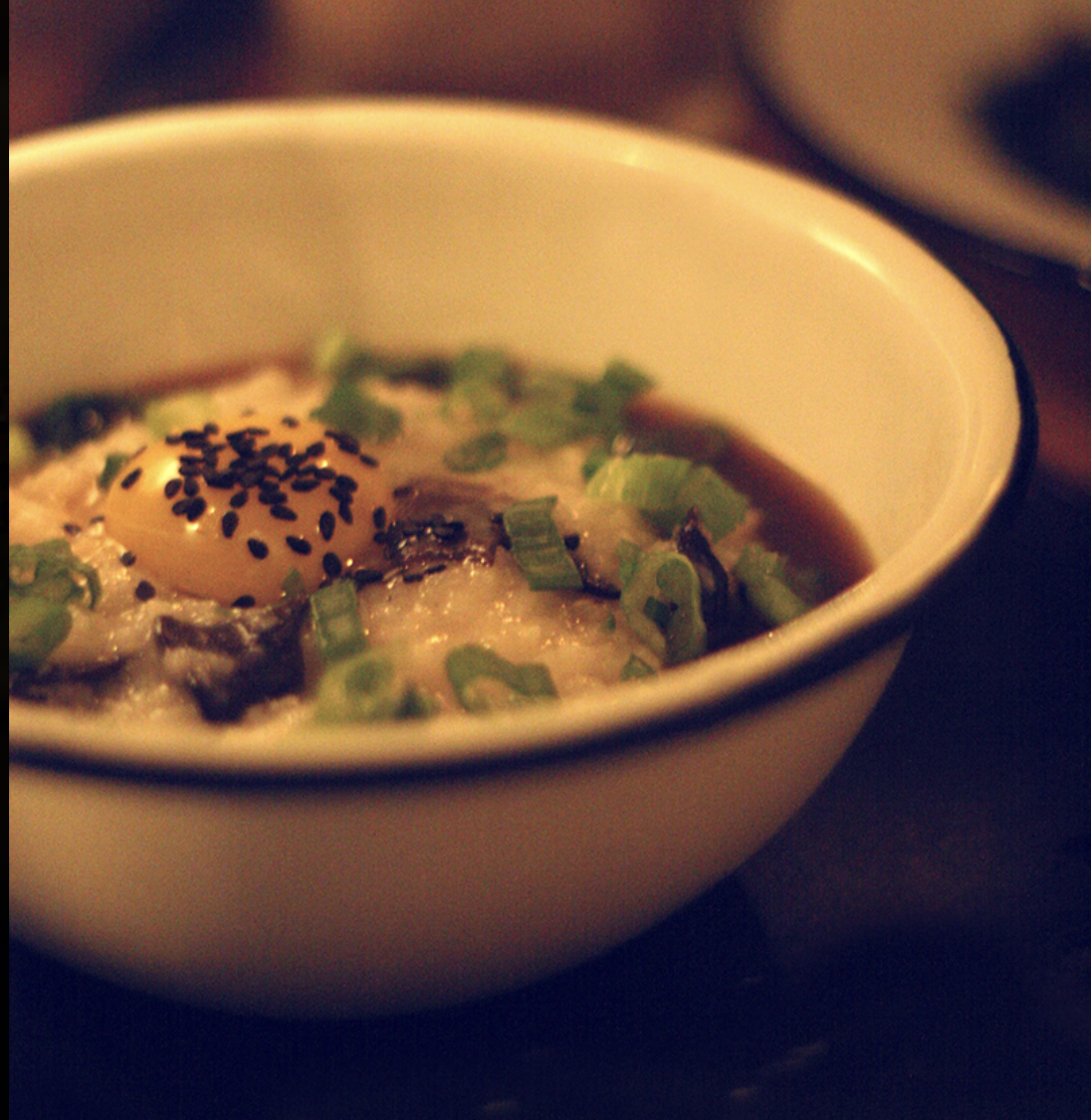 Bowl of ramen topped with a soft-boiled egg, green onions, and sesame seeds.