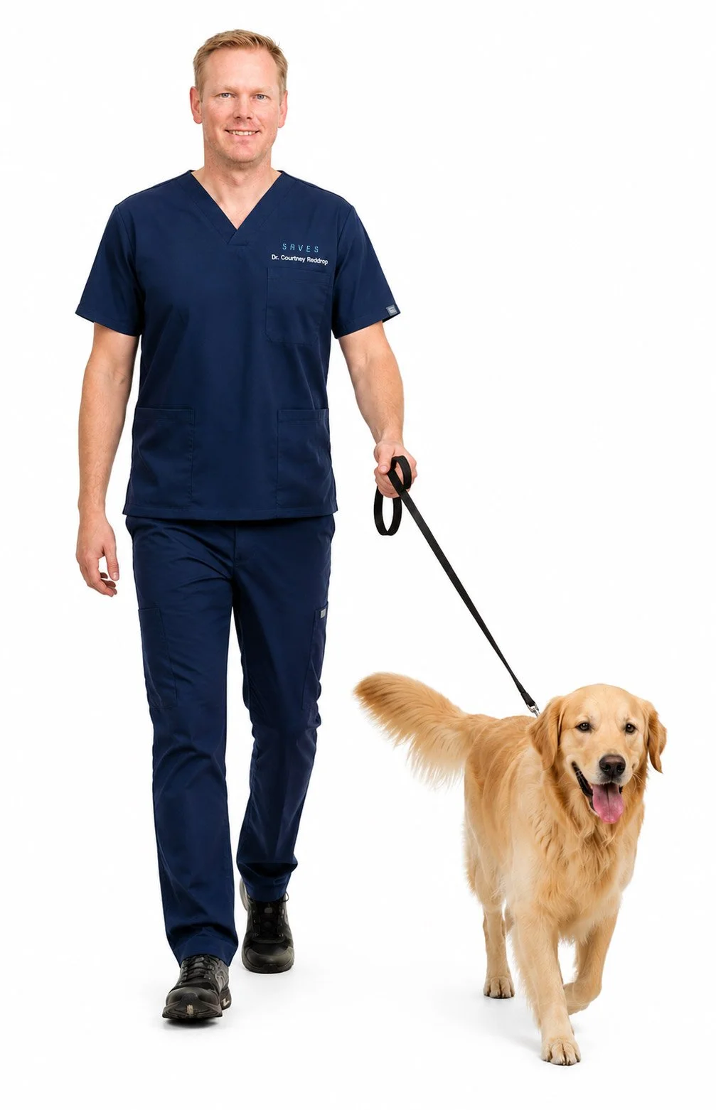 A man in navy medical scrubs walking a service dog on a leash, both smiling, on a white background.