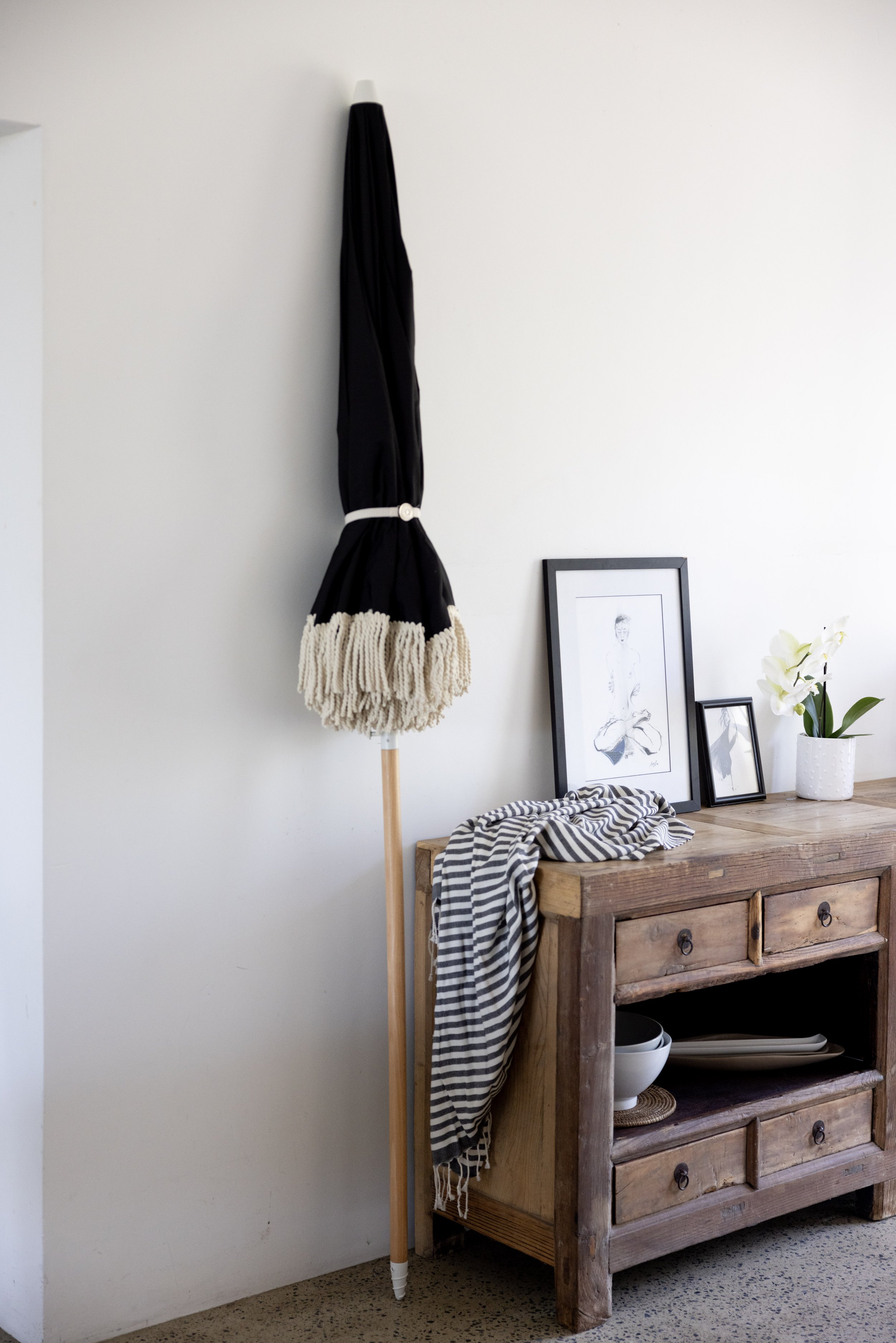 Rustic console table adorned with decor and a woven tote bag, adding charm to Haven Tropicana.