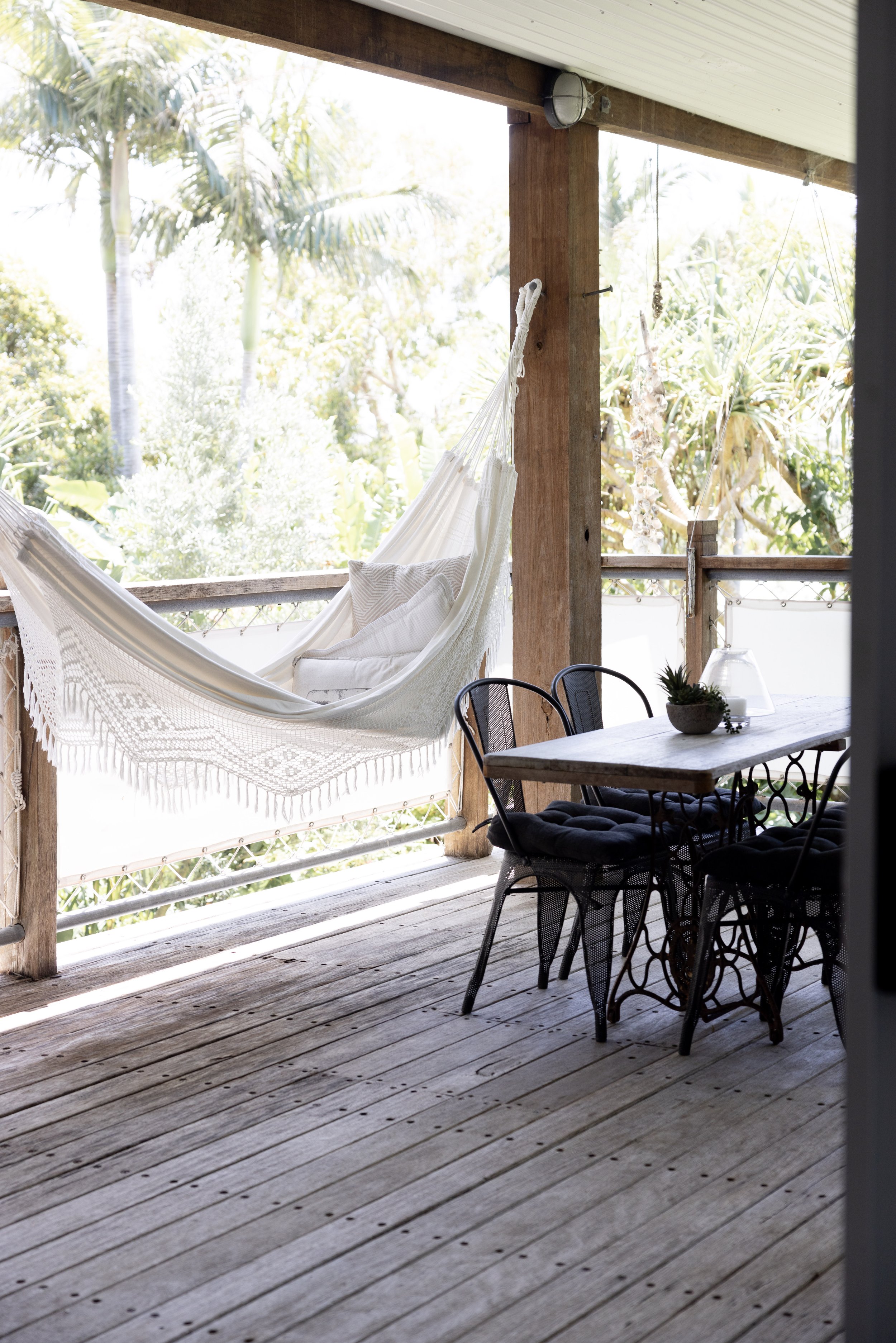 Covered north-facing deck with a hammock and outdoor dining area at Haven Tropicana.