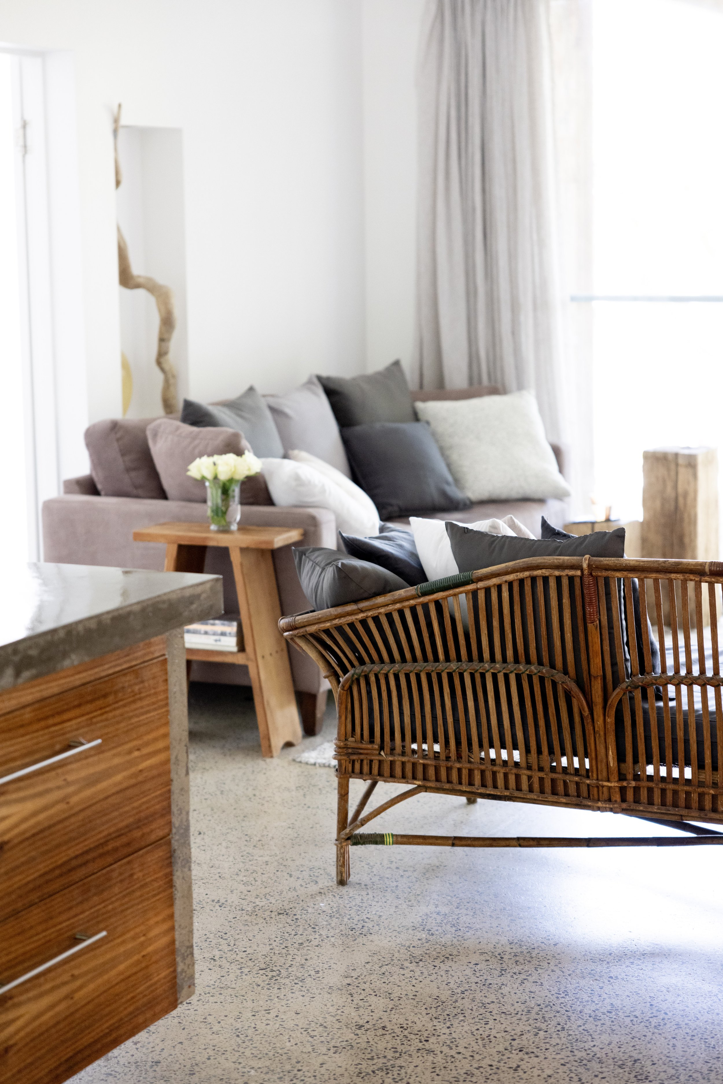 Cosy living area with antique cane seating, wool rug, and warm natural tones at Haven Tropicana.