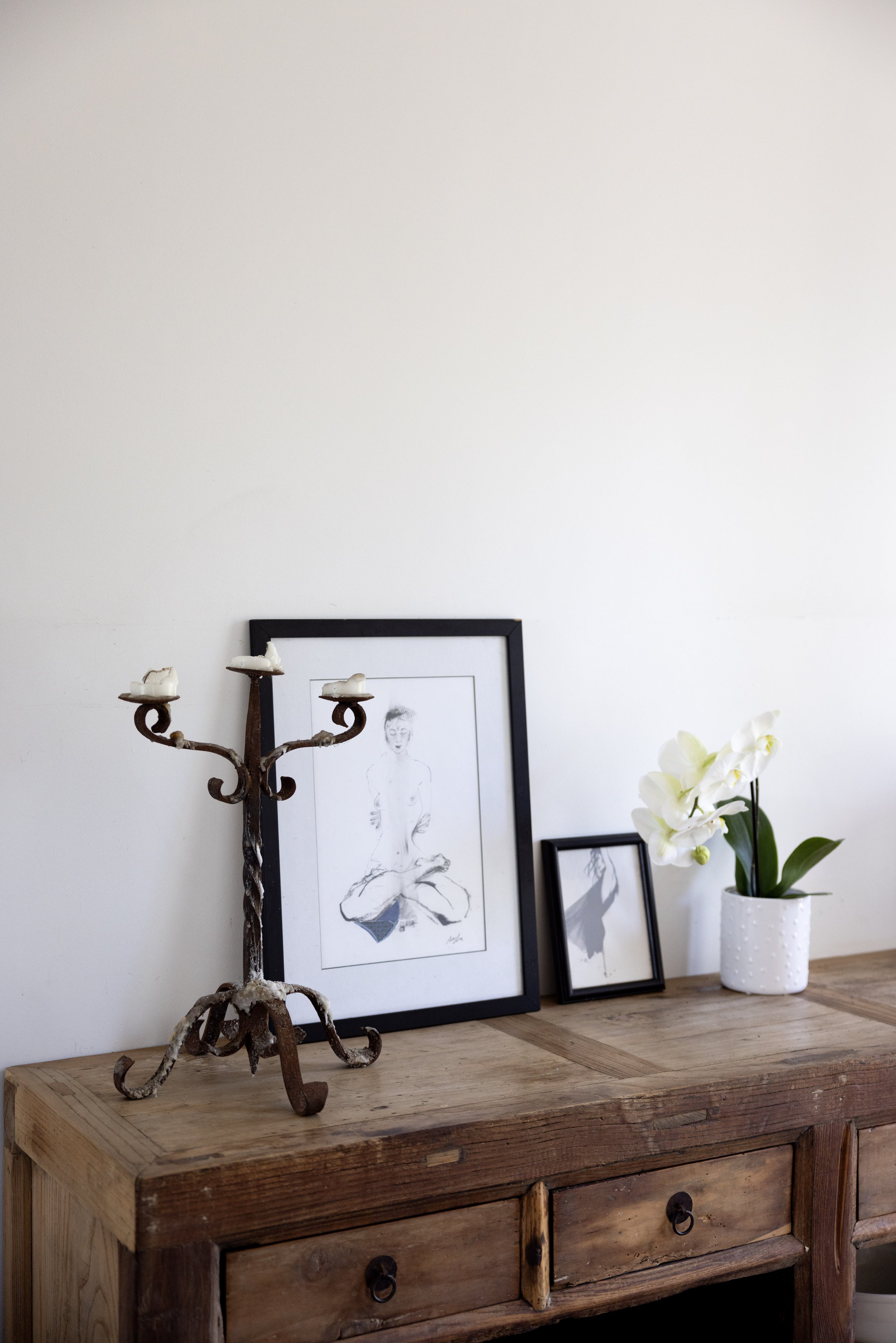 Elegant vignette featuring framed coastal artwork and rustic candleholder at Haven Tropicana