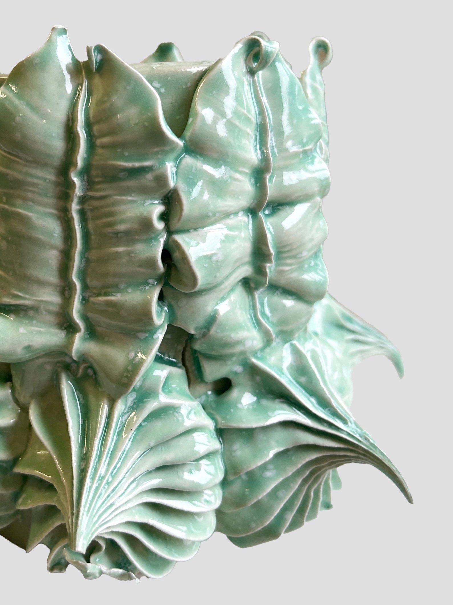 Vase en céramique de couleur verte avec un motif de feuilles stylisées, très détaillé et glossy.