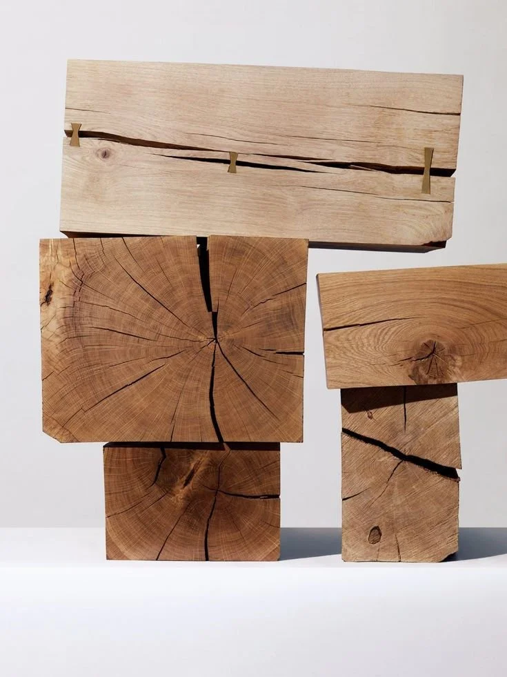 Cuatro bloques de madera cortados, uno sobre otro, con grietas visibles en cada uno.
