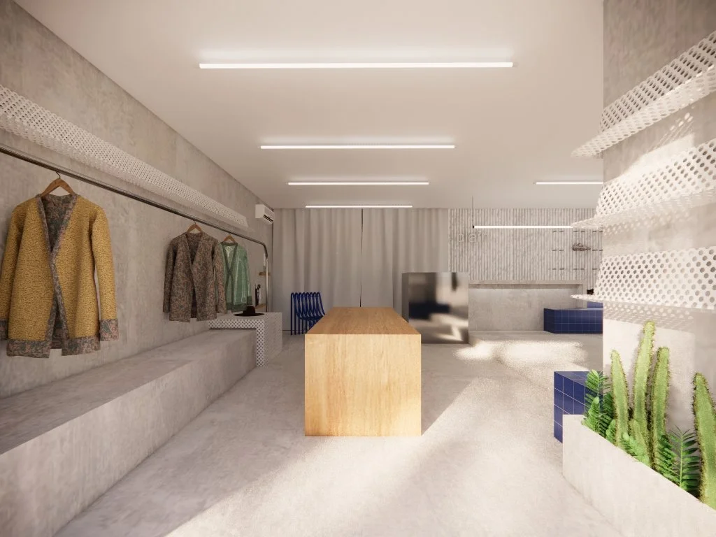 Interior de una tienda o showroom con ropa en exhibición, muebles de salón y plantas cactus decorativas. Retail design en barcelona. microcemento