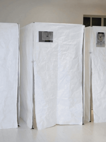Estructuras de cartón cubiertas con papel blanco, con pantallas pequeñas en la parte superior.