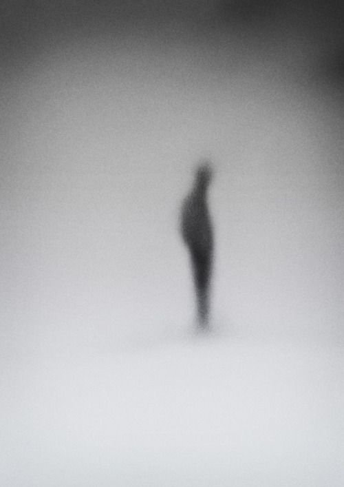 Silhouette borrosa de una figura humana en un fondo gris
