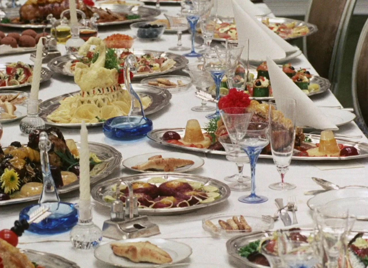 Mesa decorada con diferentes platillos y copas en una comida o banquete elegante.