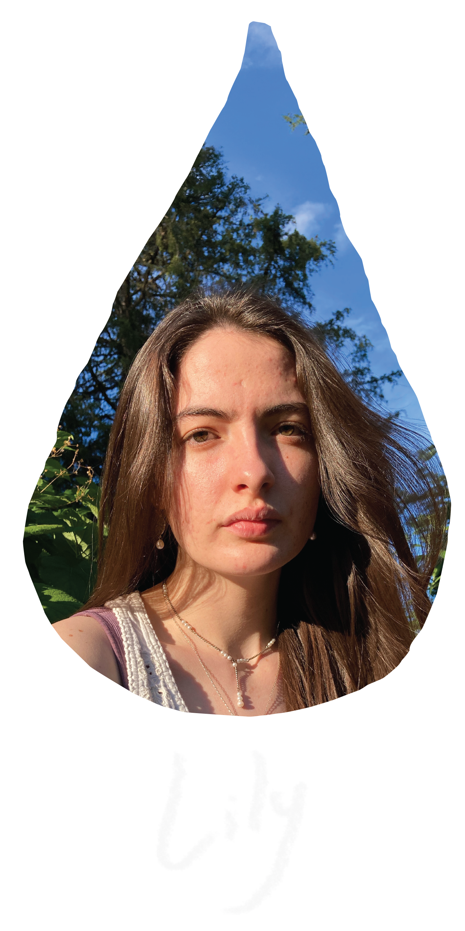 A raindrop shaped image of Lily, a young white woman with waivy brown hair wearing a white top, is looking straight to the camera with a neutral expression. She is outside, the background is greeny leaves and trees.