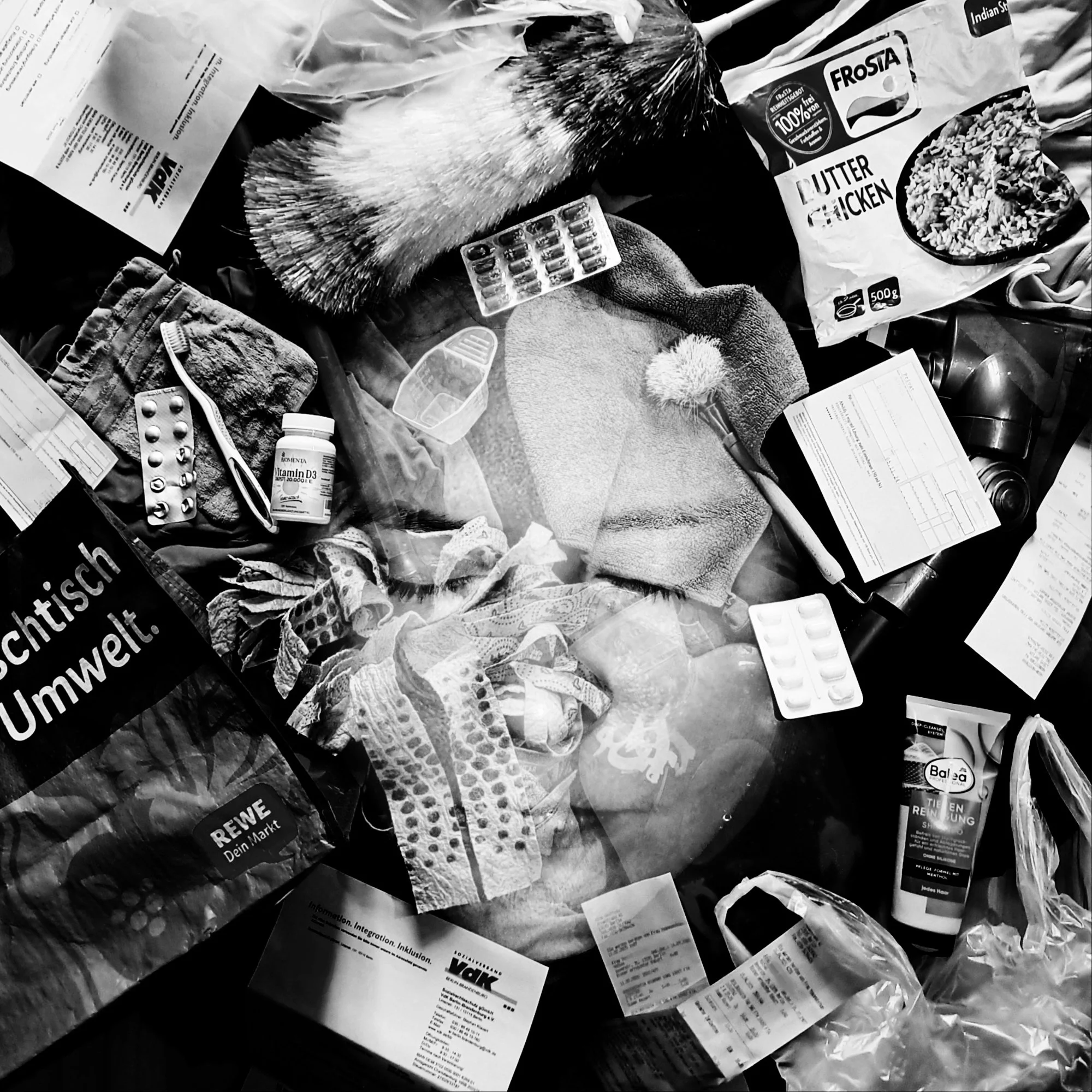 A black-and-white double exposure photo with a face in the middle and all kinds of things around it: pill strips, food packaging, a toothbrush and bills. The person in the middle has their eyes closed.