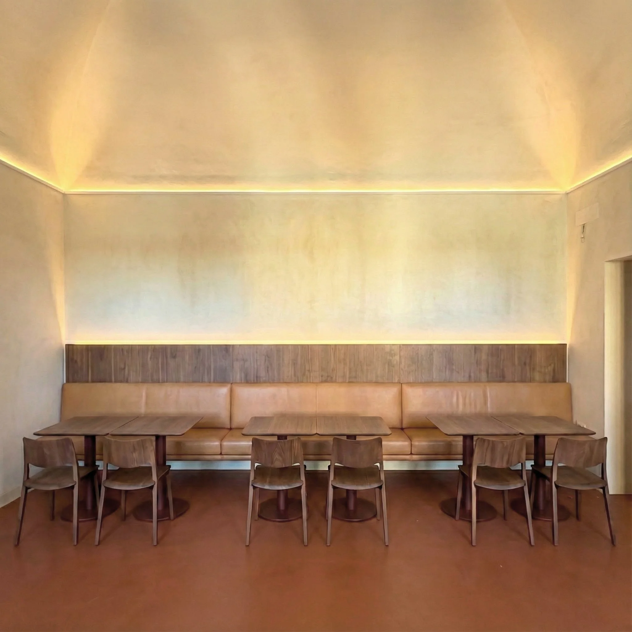 Sala de comedor con mesa de madera y sillas, paredes de color beige y candelabro en el techo.