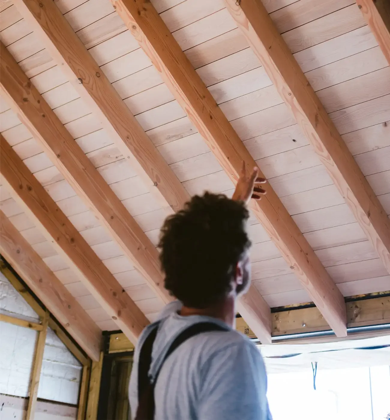 Elements Build team inspecting exposed timber rafter ceiling during construction, Cornwall