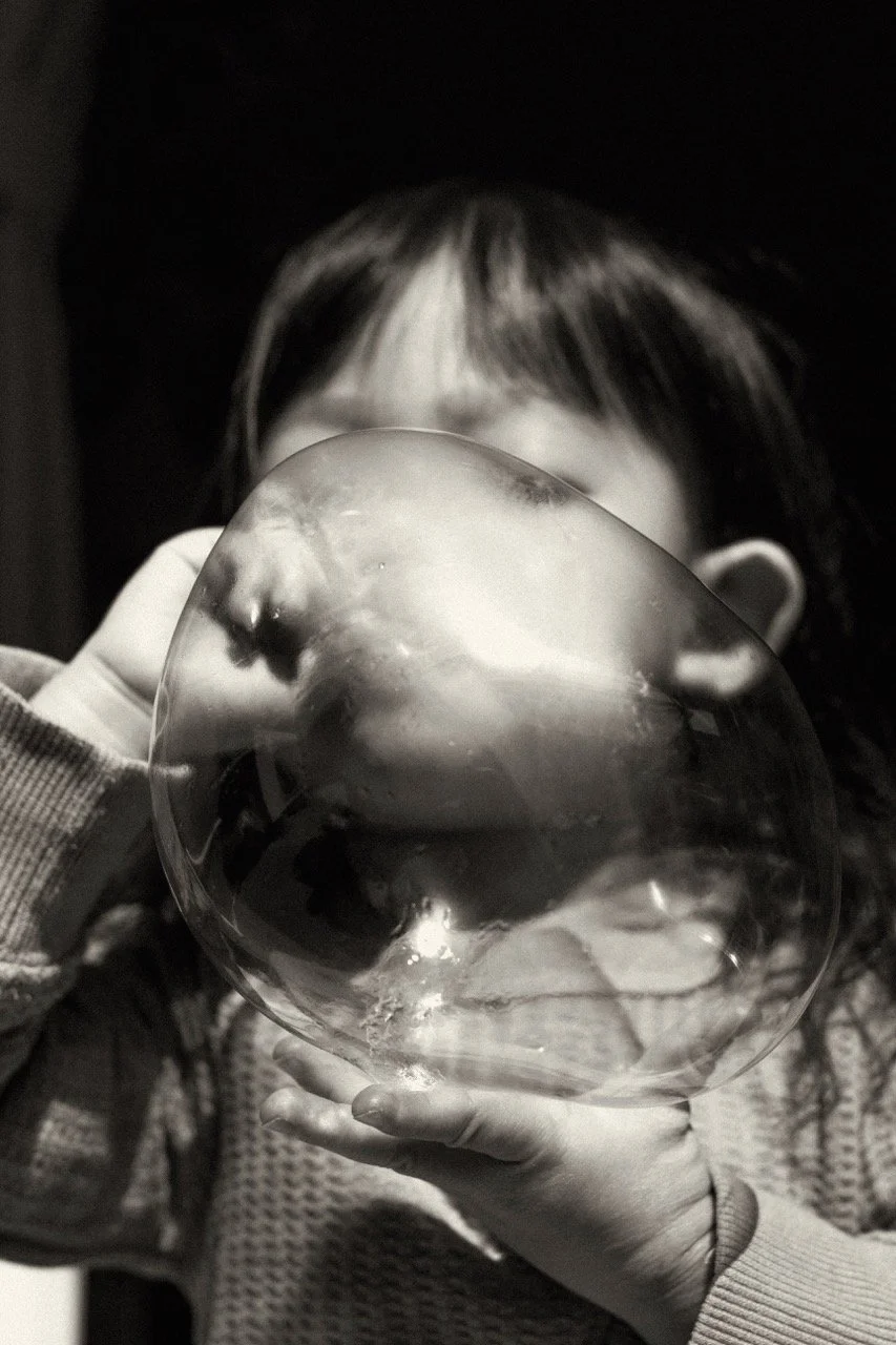 portrait of a child during playtime with bubble balloon— an artistic, playful photograph from a family lifestyle session. Documentary family photography by Noa Nguyen, Tokyo for expat families.