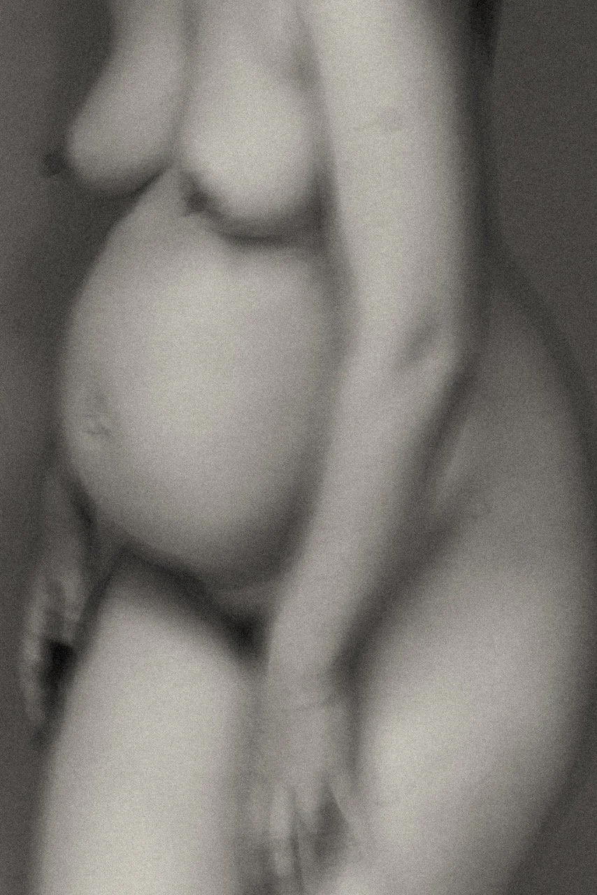 Soft focus black and white photograph of a pregnant body, motherhood  in blooming — an artistic maternity portrait celebrating the changing form. Maternity photography in Tokyo by Noa Nguyen. featured on Photo Vogue