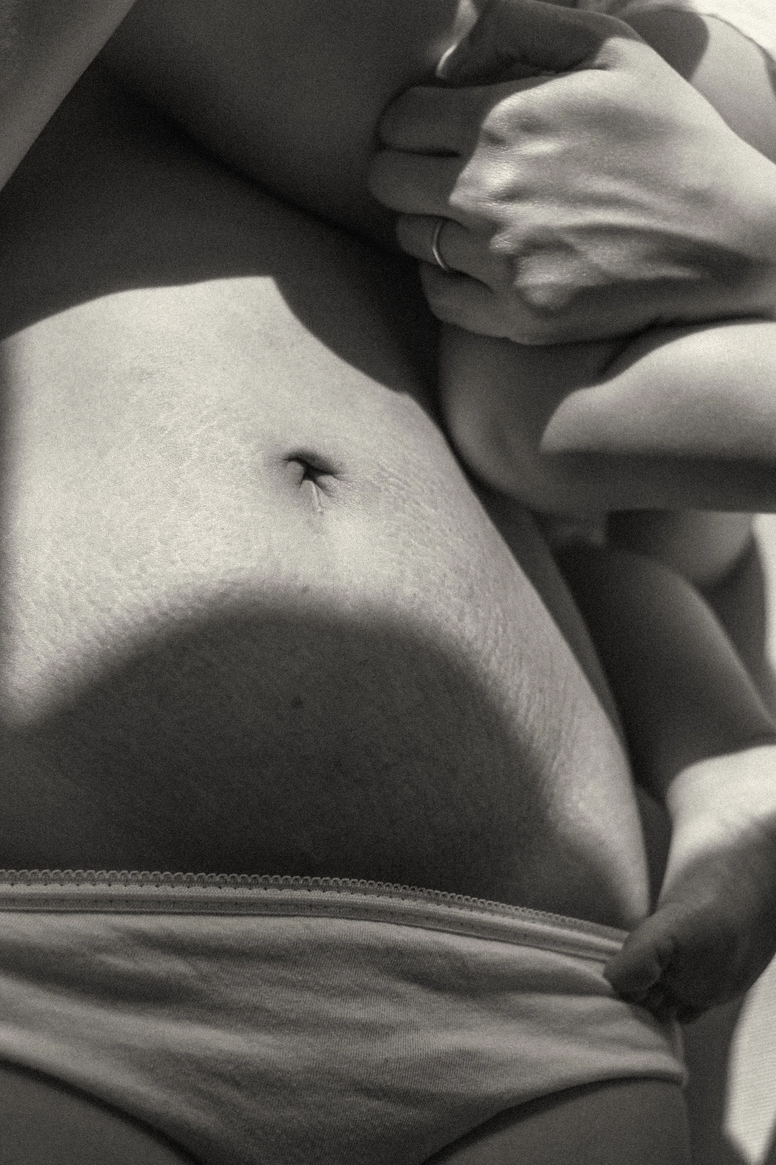 A soft-focus documentary image of a mother's belly and stretch marks, celebrating the permanent "curves of creation" on the skin. featured on Photo Vogue