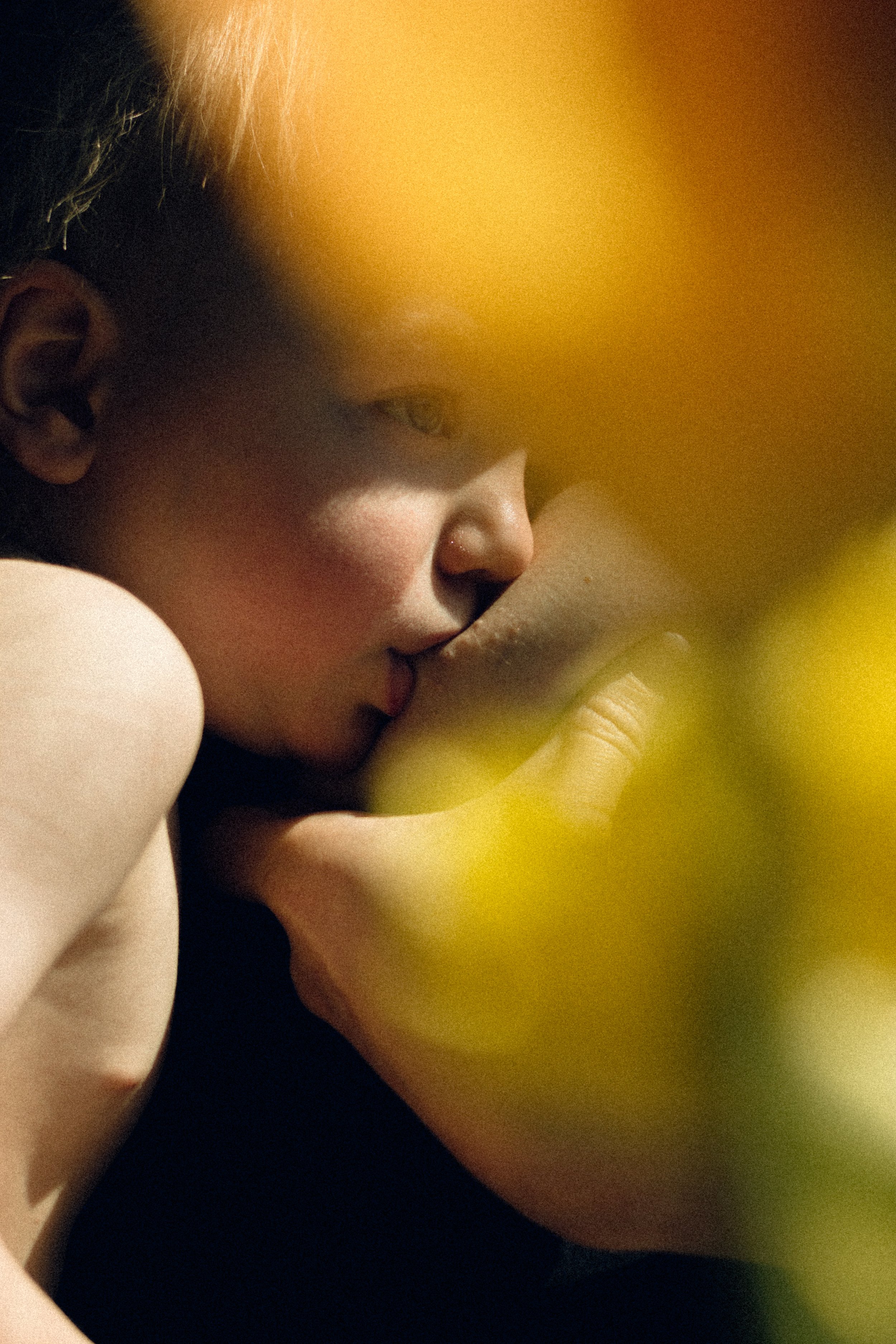 An artistic intimate moment of a mother nursing a toddler at home in Tokyo with natural light photography. featured on Photo Vogue