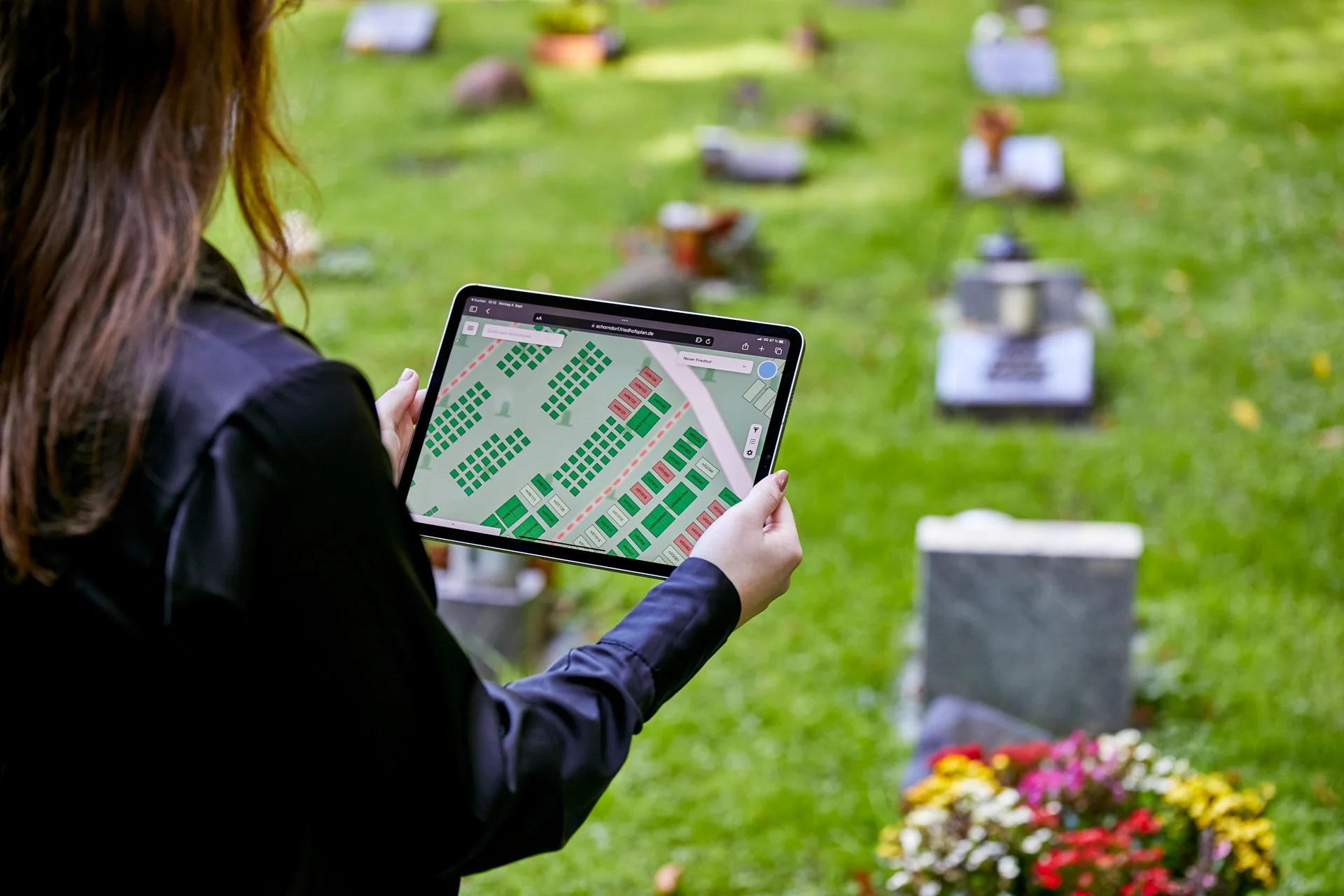 Der digitale Friedhofsplan auf dem Ipad wird auf dem Friedhof in den Händen gehalten