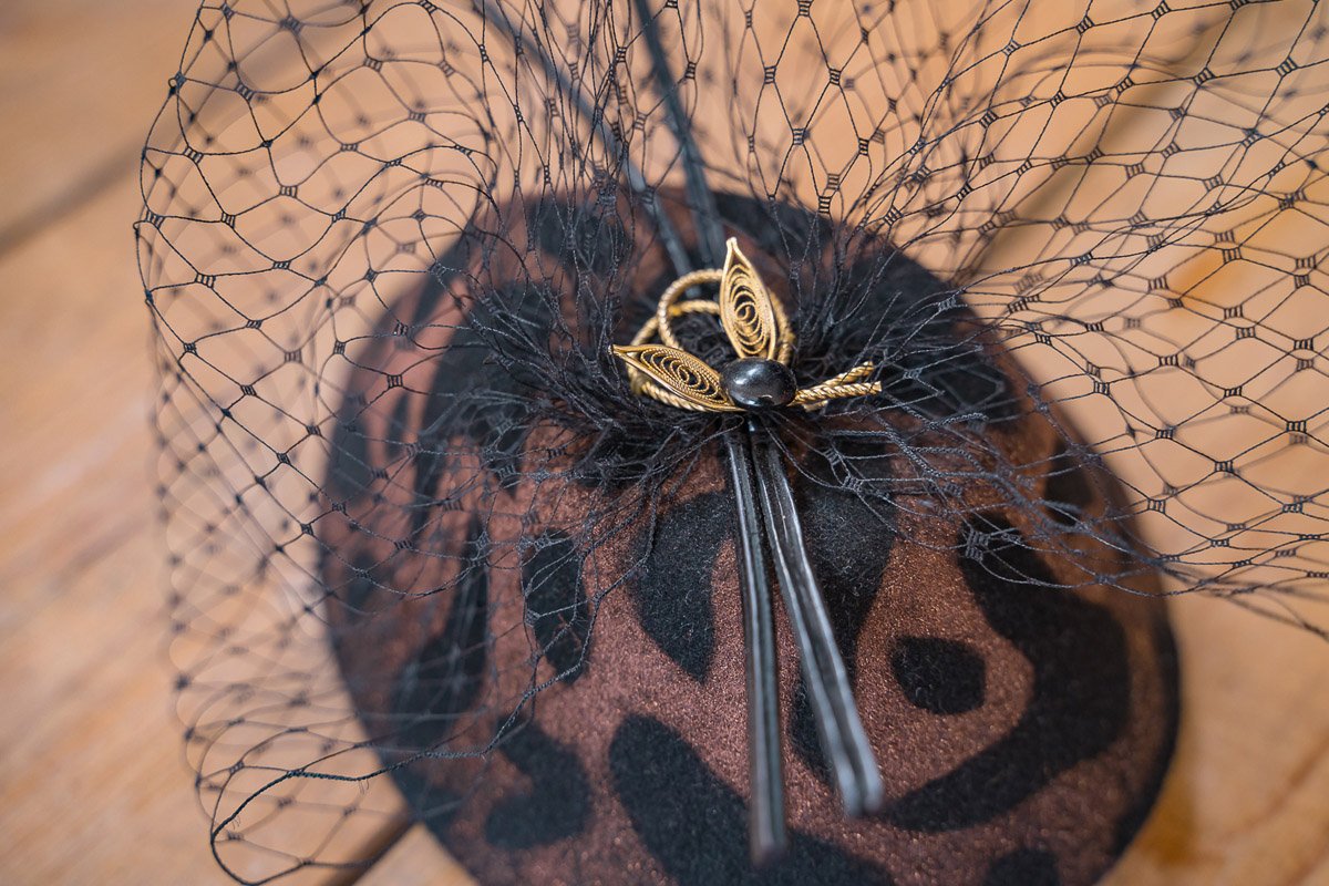 Handcrafted fascinator with leopard print design, gold bow and black netting