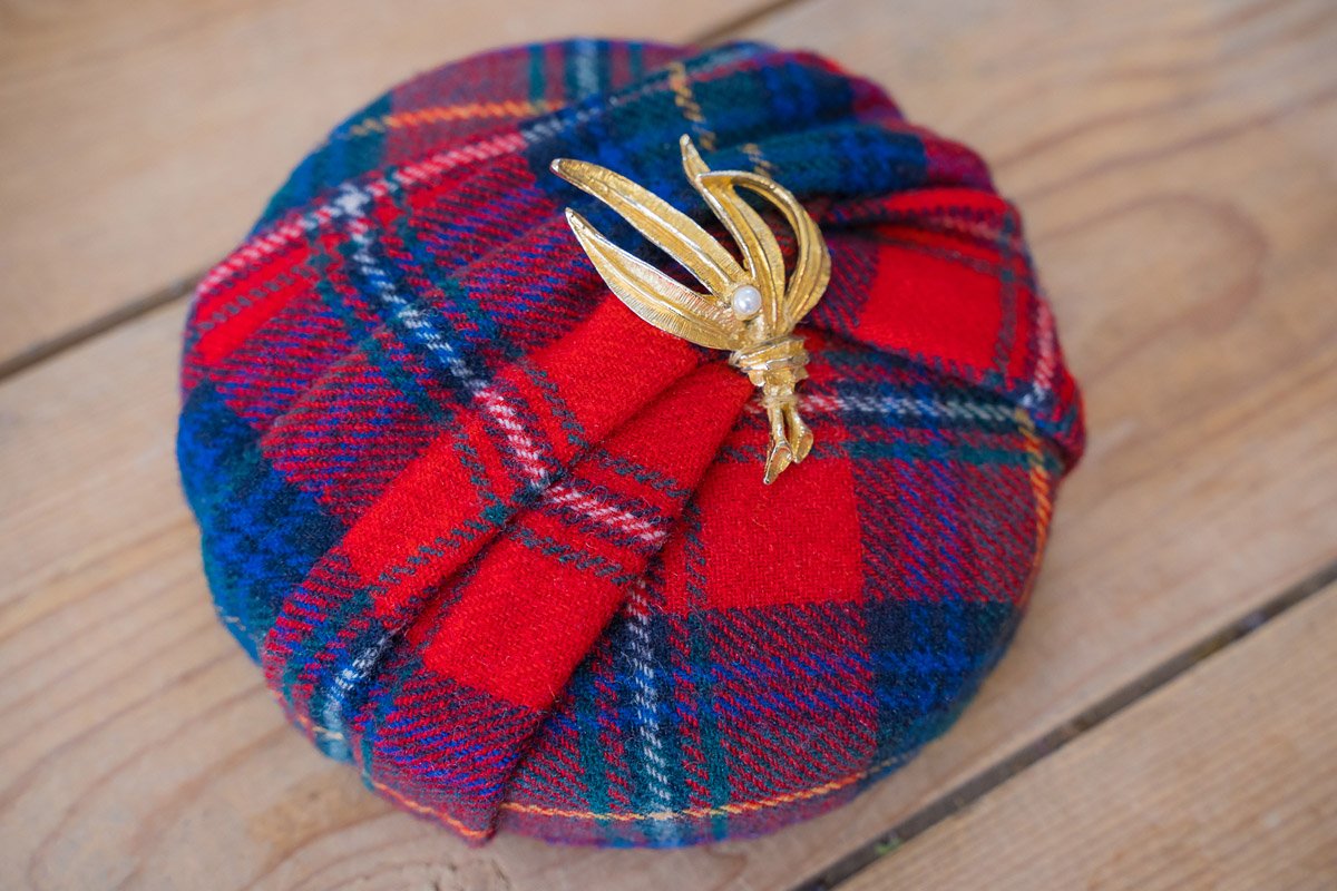 Button fascinator covered in a traditional vintage tartan red and blue fabric with a gold vintage brooch