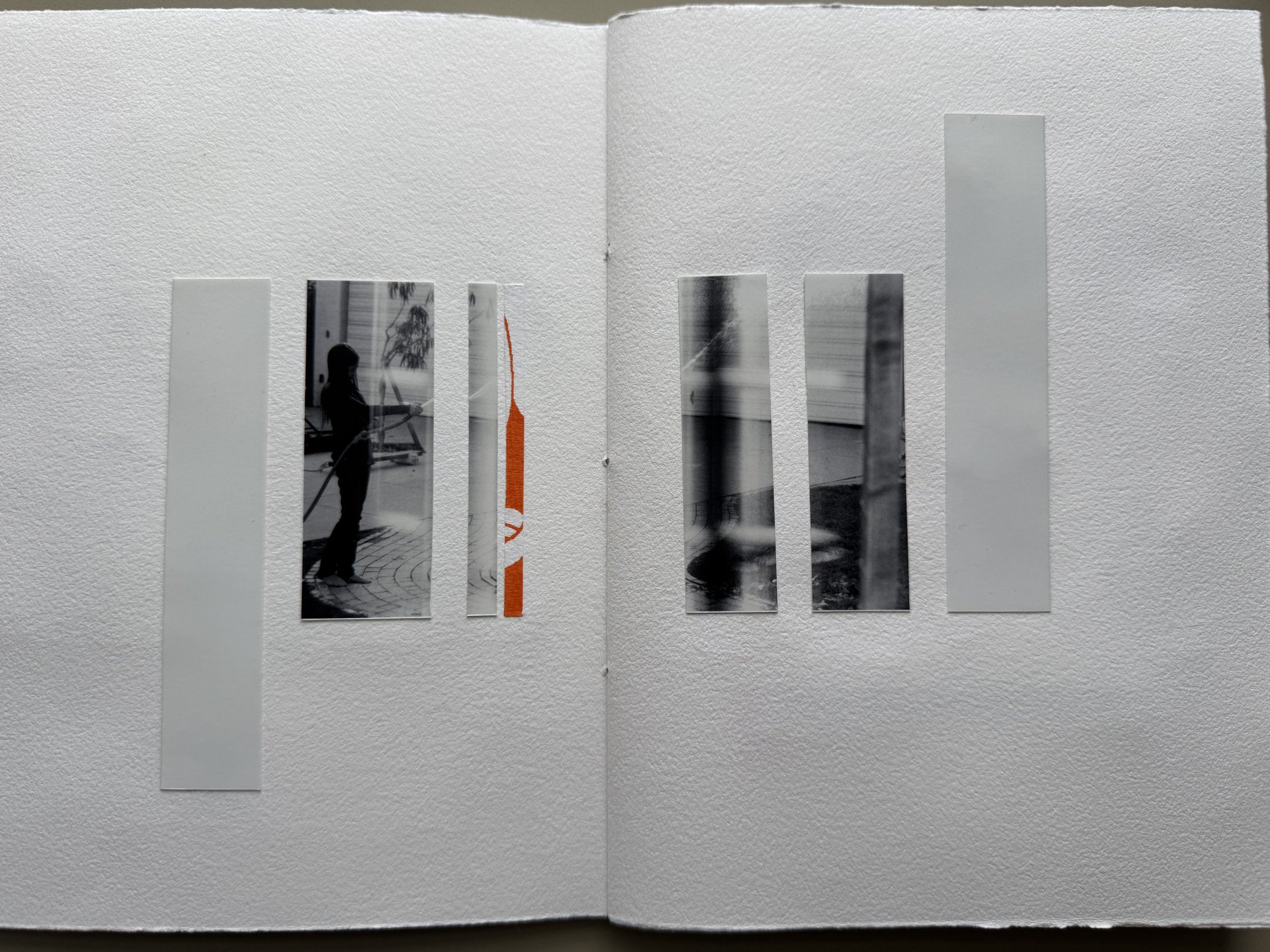 A white textured wall with strips of black and white photographs and a strip with orange text.