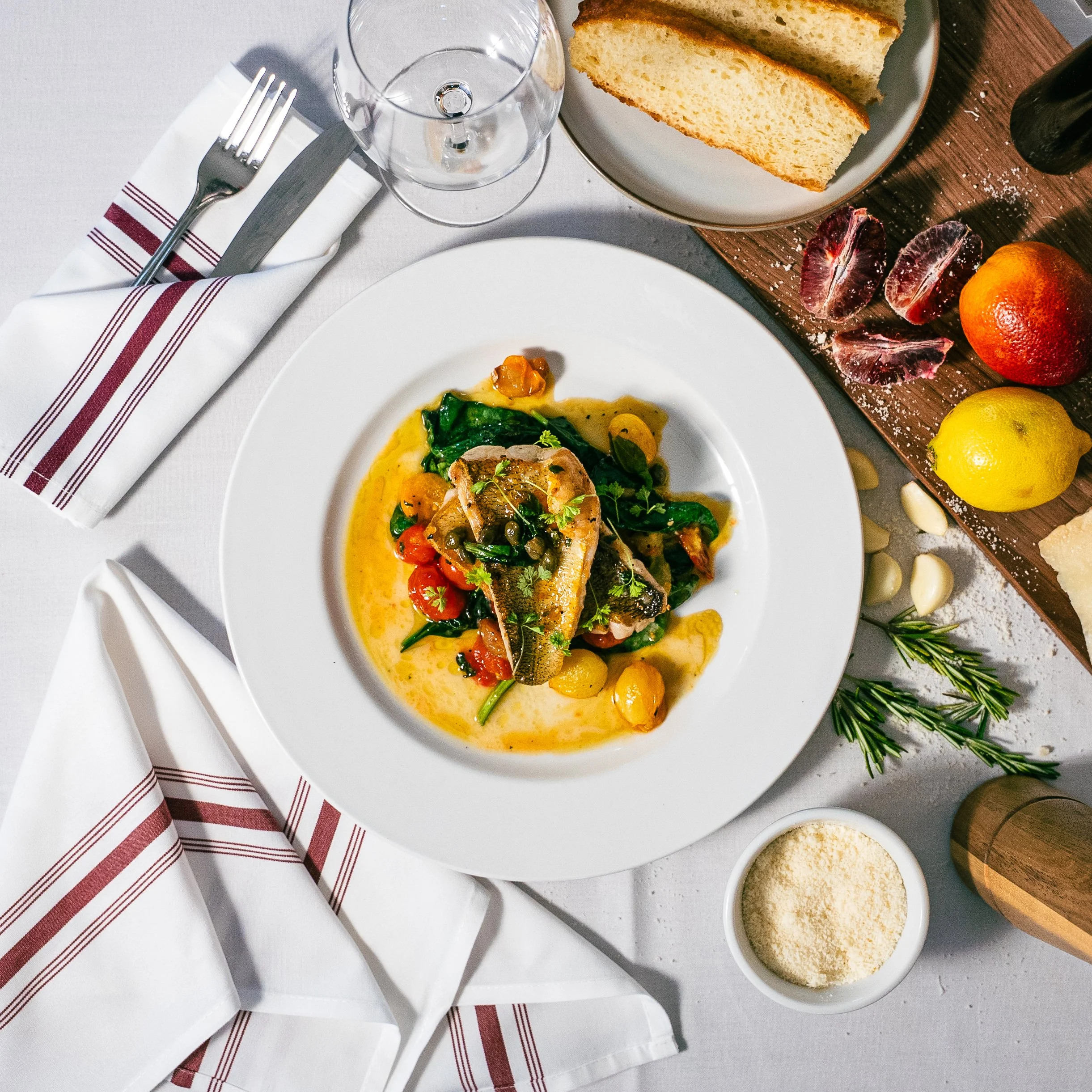 Pan Seared pickerel, lemon caper butter, preserved tomato, roasted garlic, field spinach