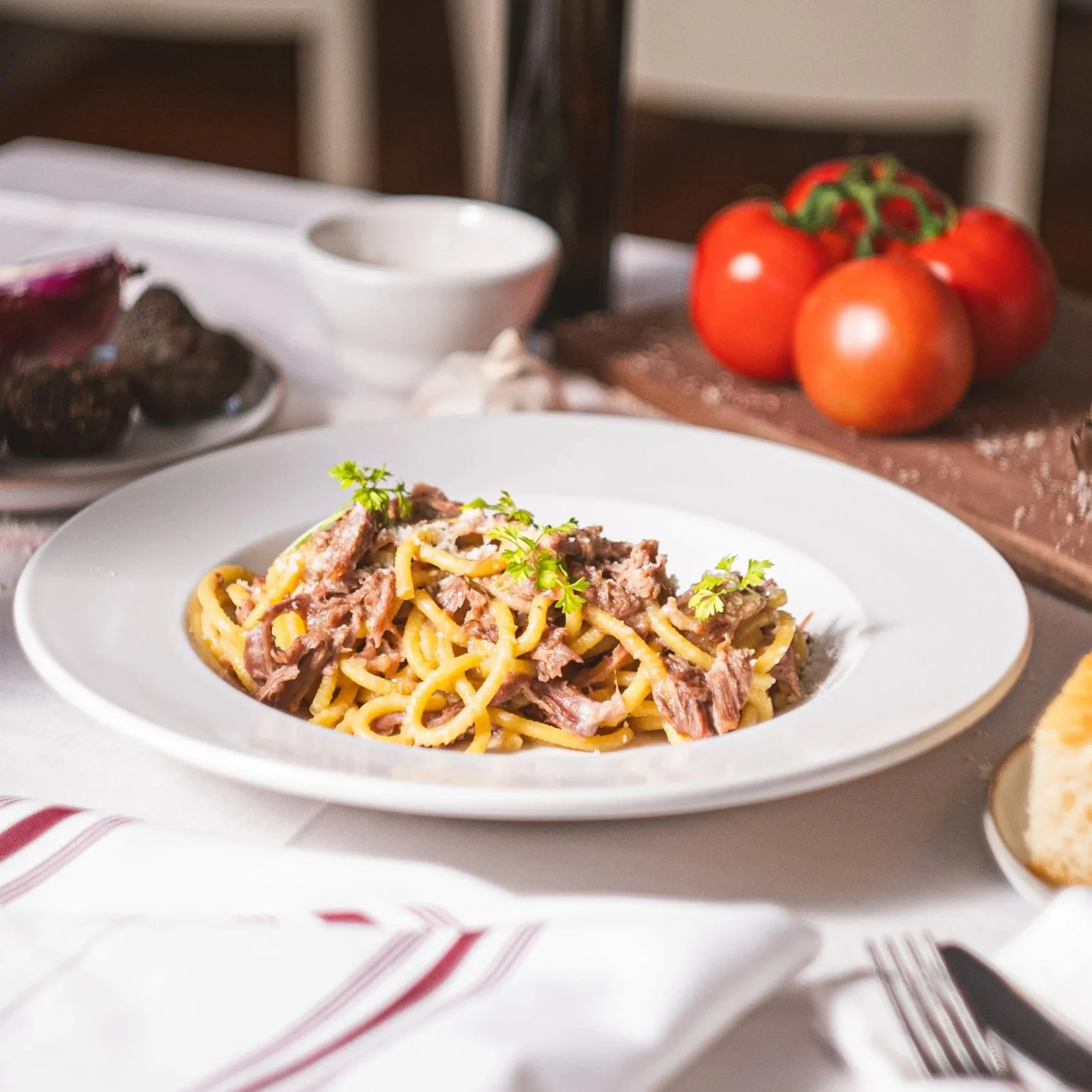 Hand-rolled Tuscan pici pasta tossed in a delicate white ragù of slow-braised duck, finished with garlic, fresh herbs