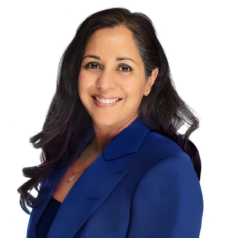 Professional headshot of a woman with dark hair wearing a blue blazer, smiling