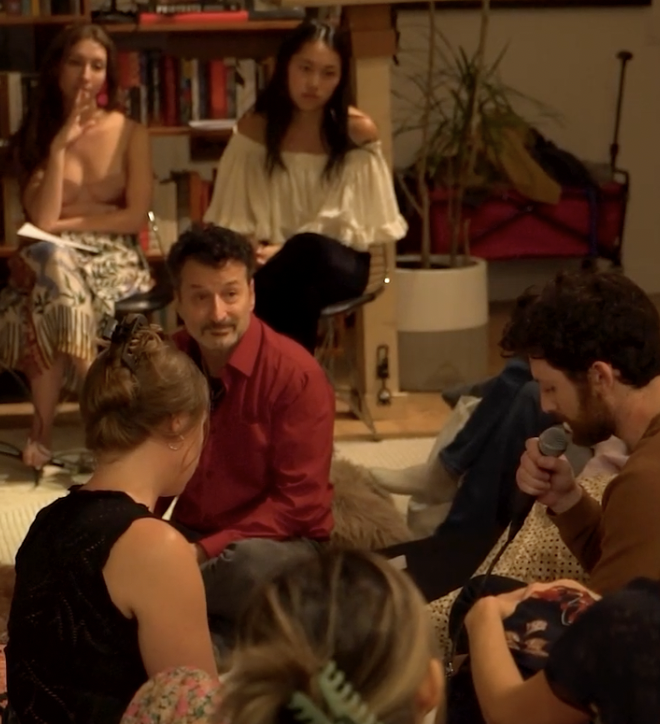 Group discussion indoors, several people sitting and listening