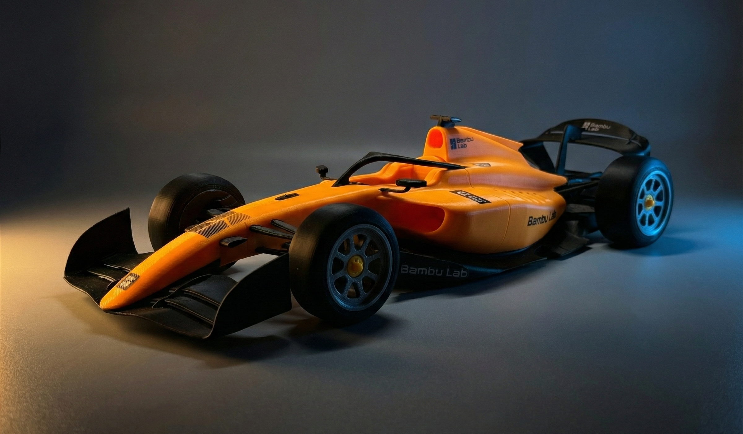 An orange 3D-printed F1 style openwheeler racecar
