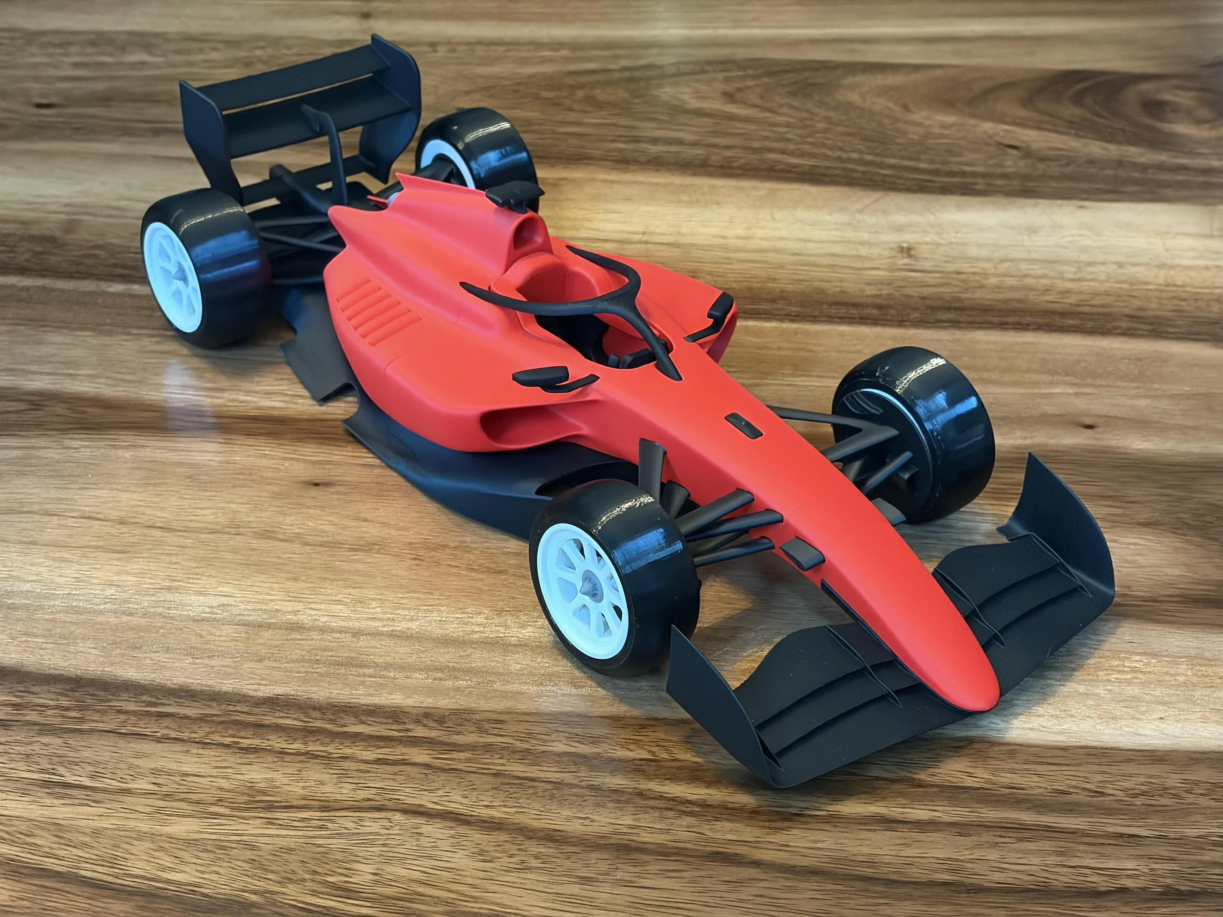 A red 3D-printed F3 inspired racecar model
