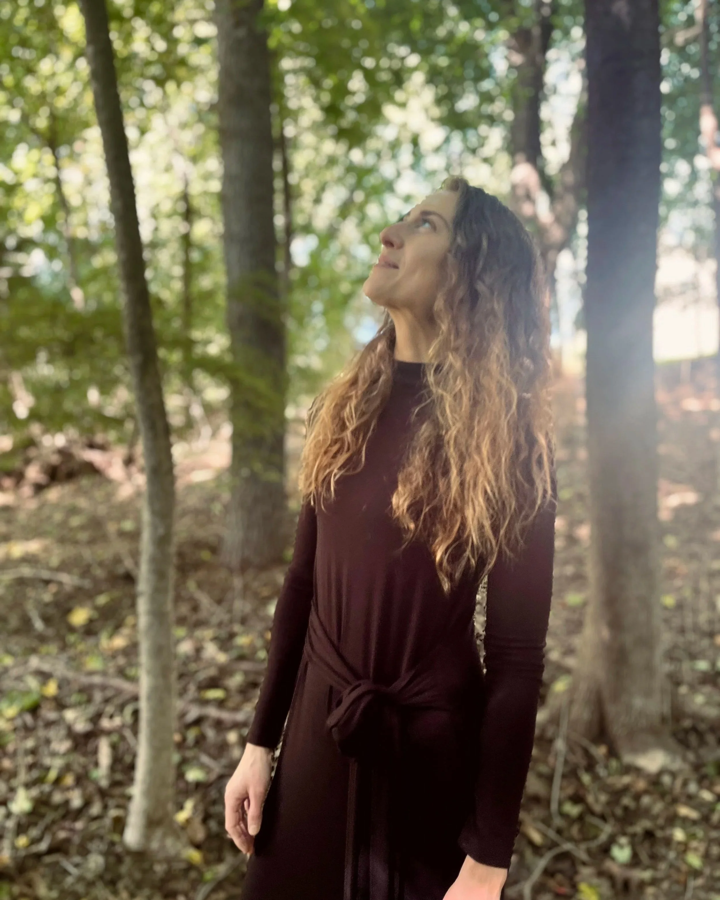 Holistic therapist standing in a forest, reflecting thoughtfully on ethical and non-pathologizing approaches to diagnosis